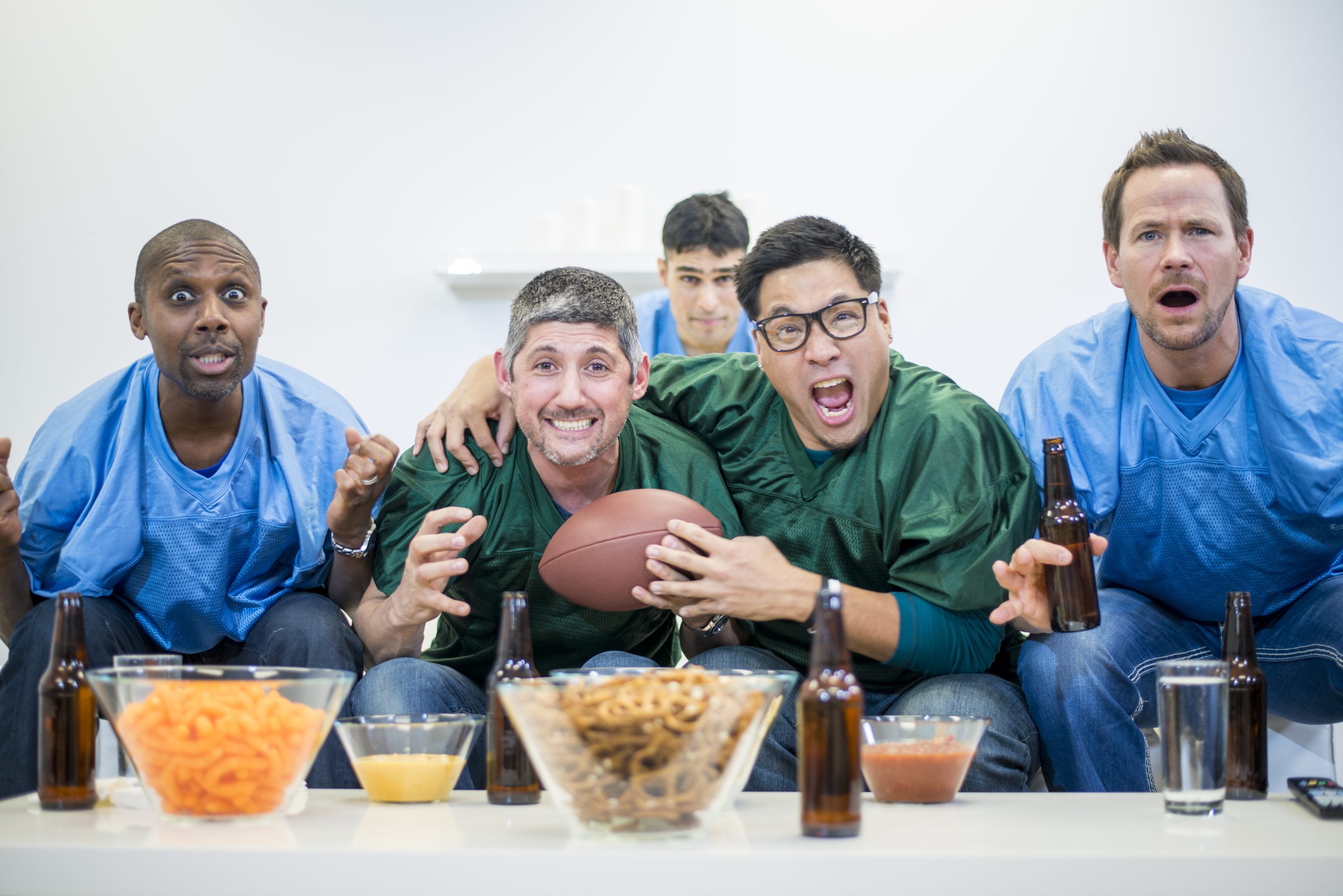 A group of guys watching American Football together and having a party.
