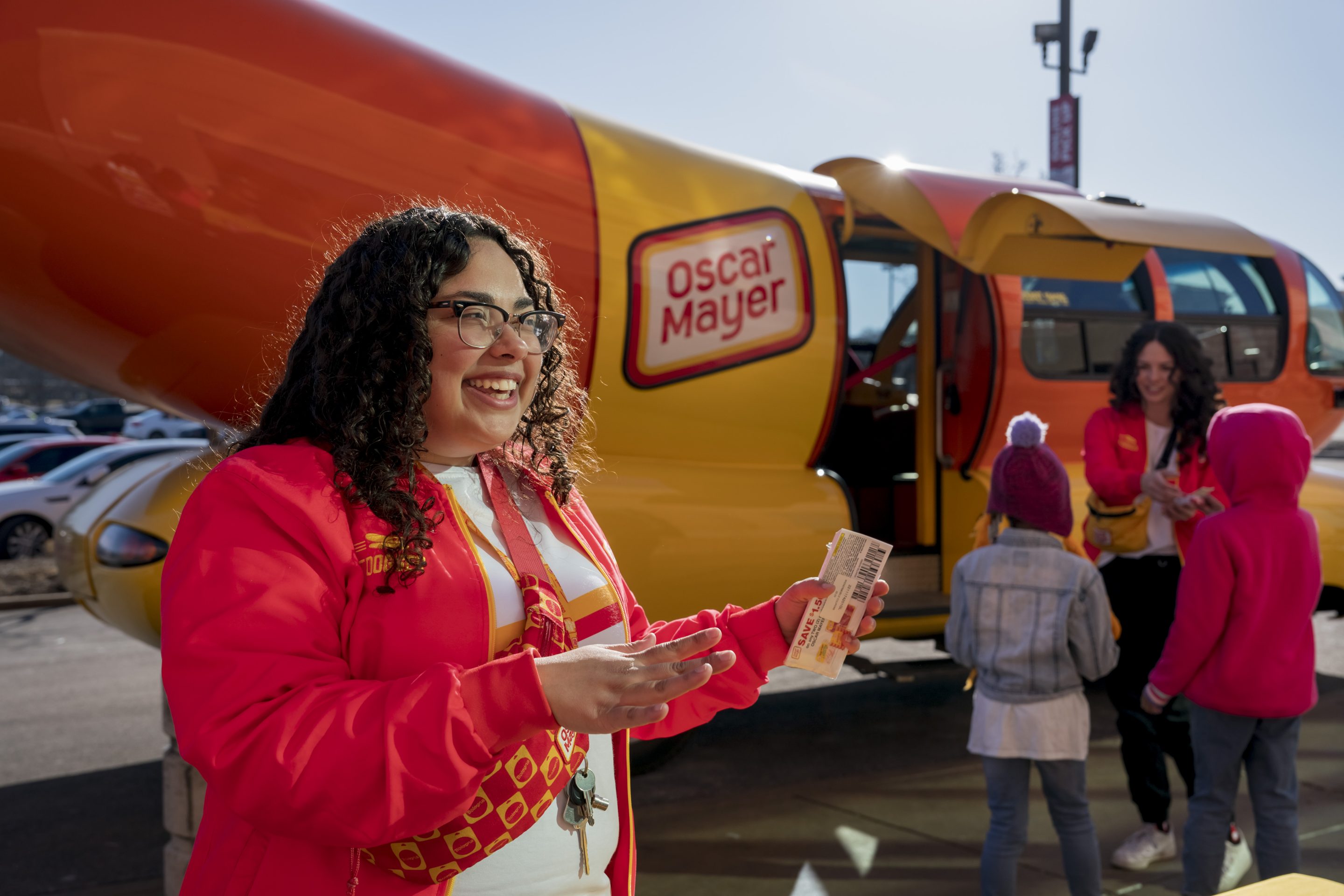 Keila Garza (L) and Shelby Lewis greet visitors at Schnucks grocery store in Florissant, Missouri, on Feb. 5, 2023. Garza and Lewis are spending one year as hotdoggers, the drivers of one of six Oscar Mayer Wienermobiles.
