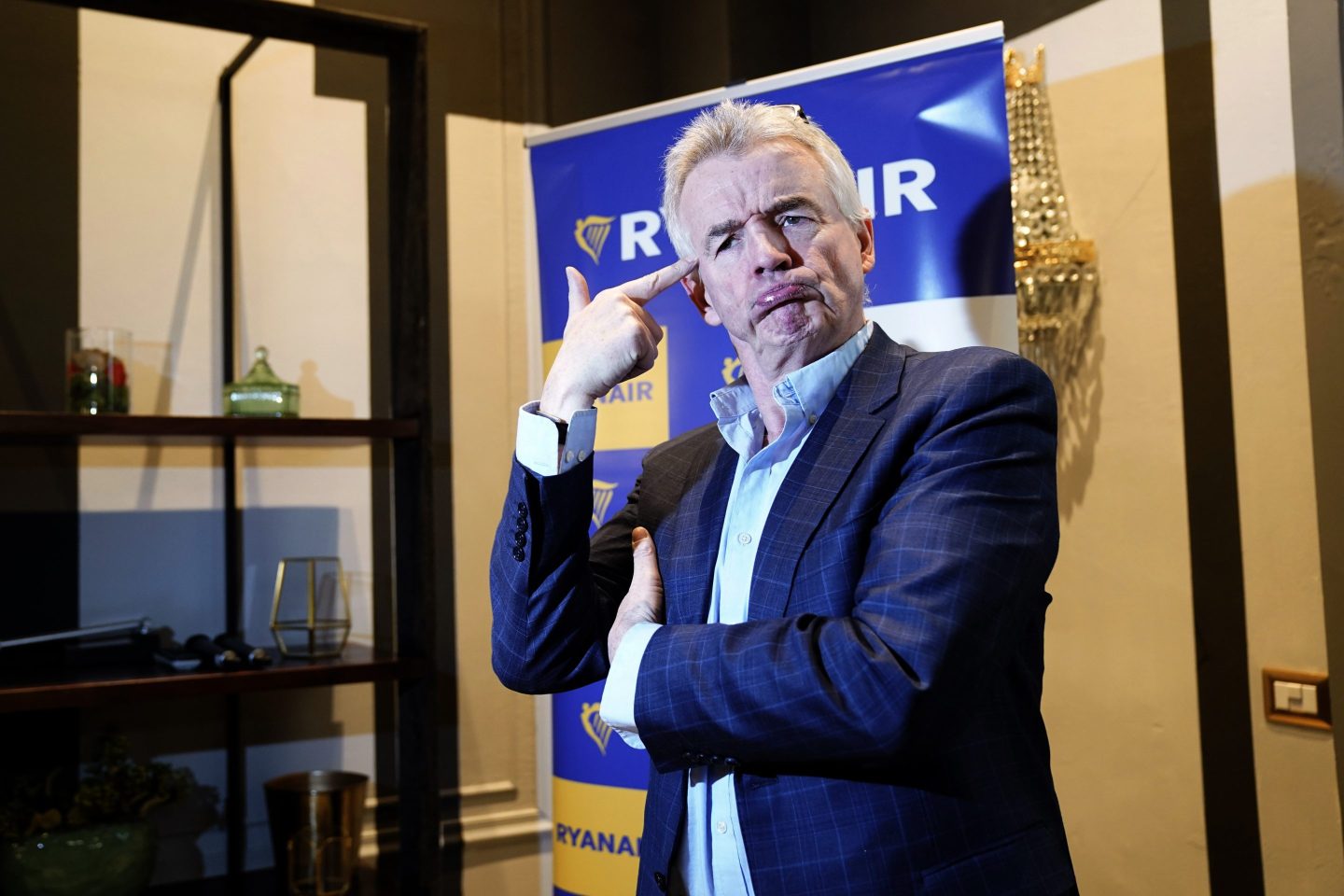 michael o'leary standing with arms folded and one arm up by his forehead