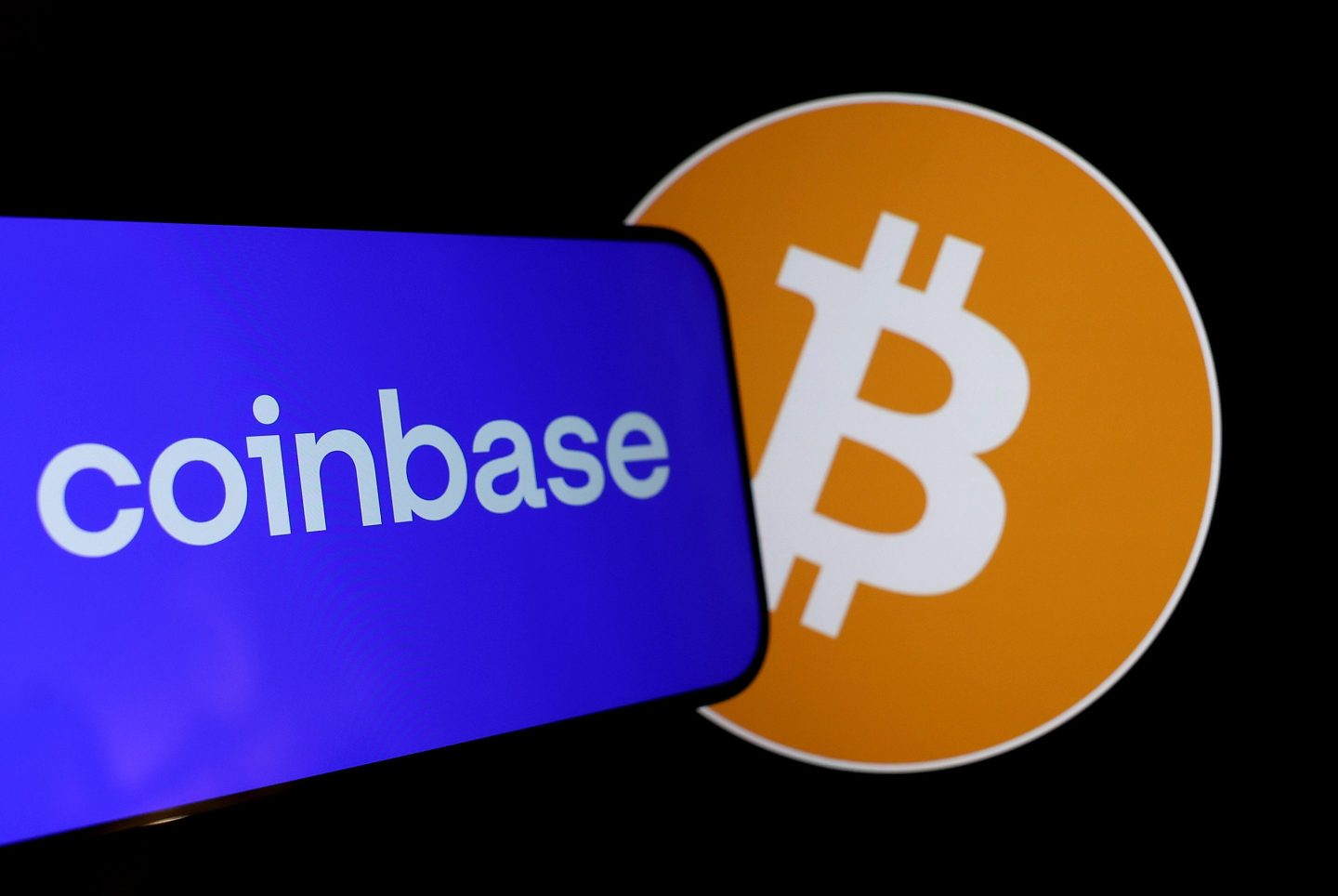 Photo showing the logos of Coinbase and Bitcoin overlapping