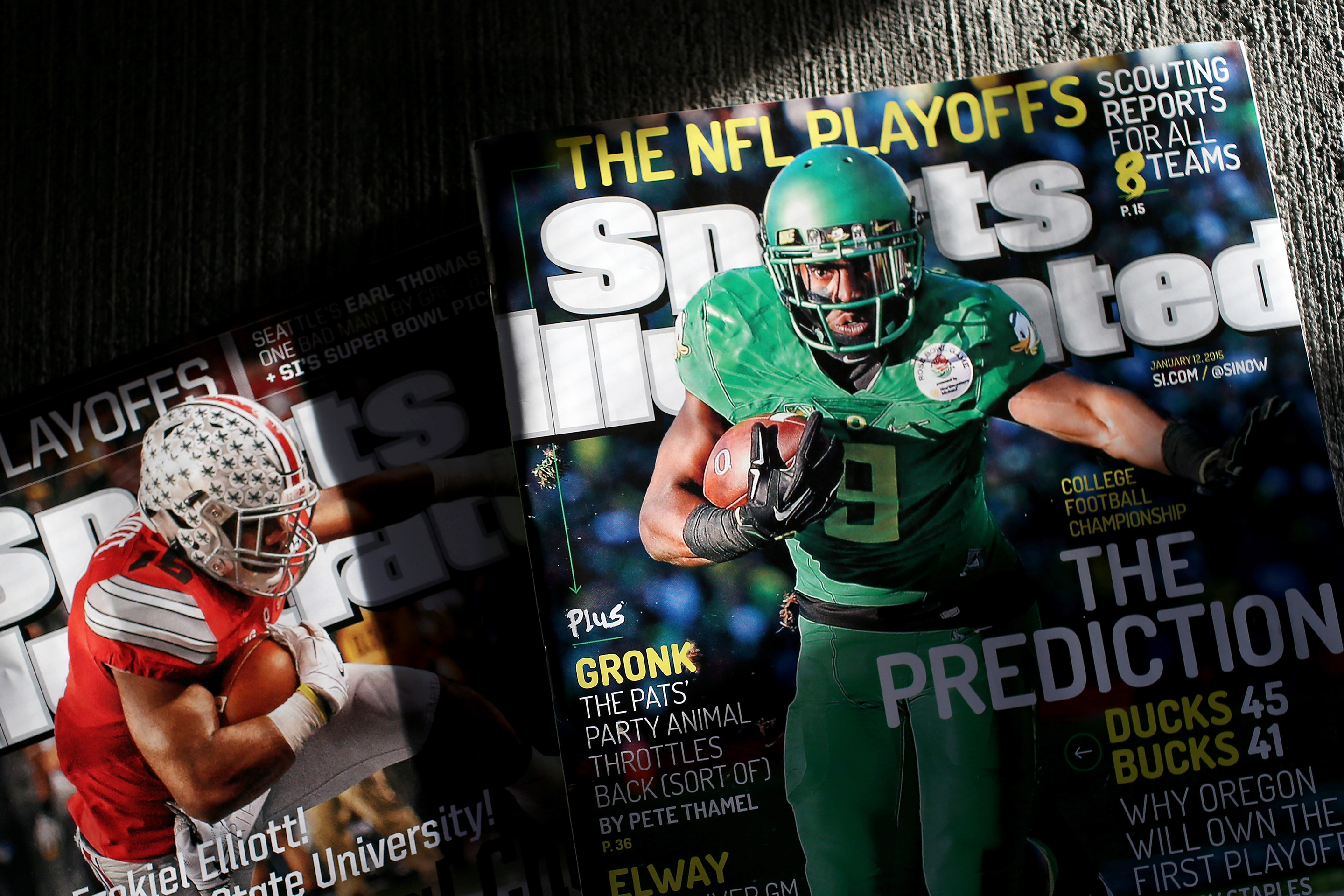 Two Sports Illustrated magazines displayed on a floor.