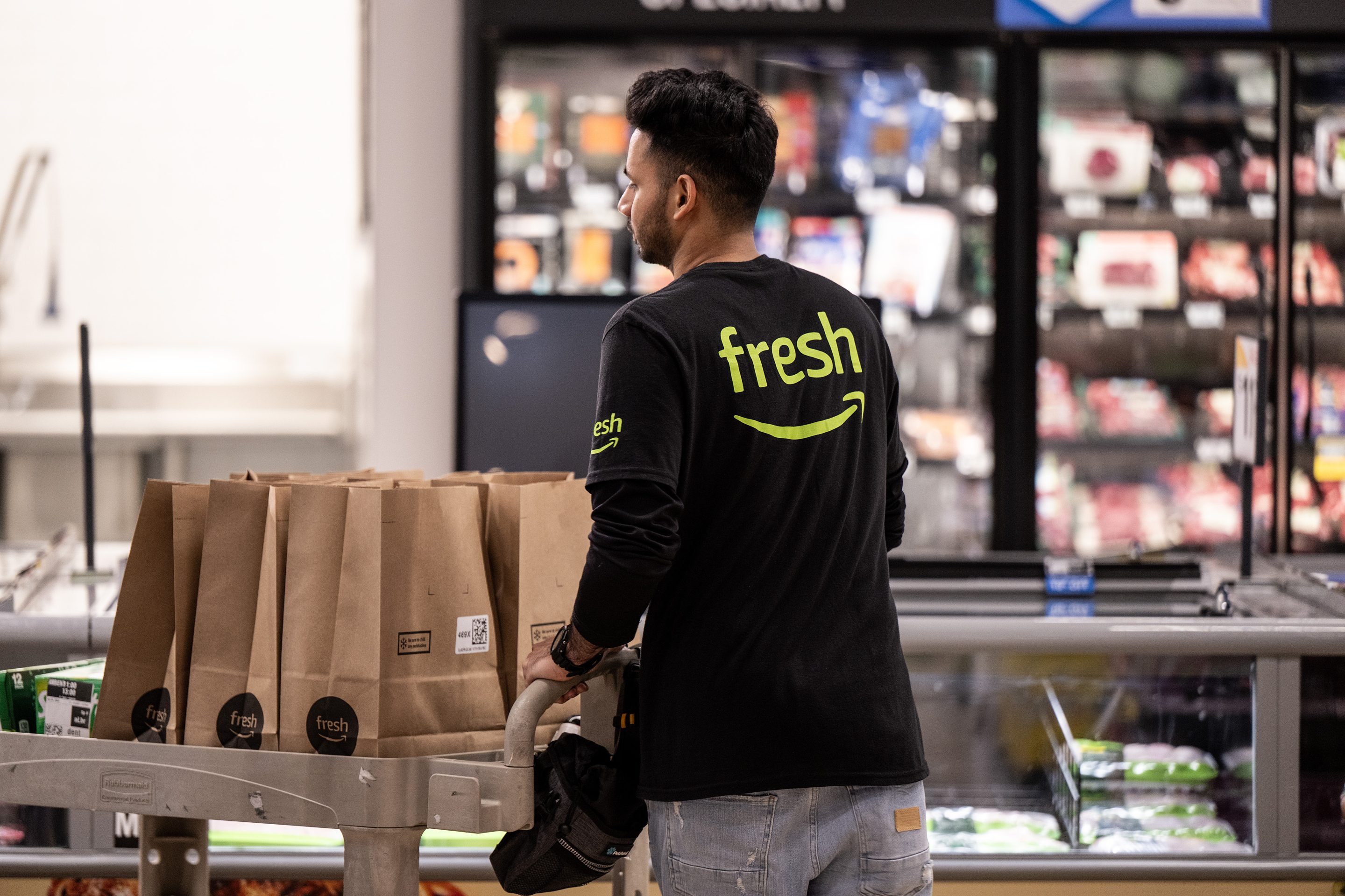 An employee prepares deliveries at an Amazon Fresh grocery store.