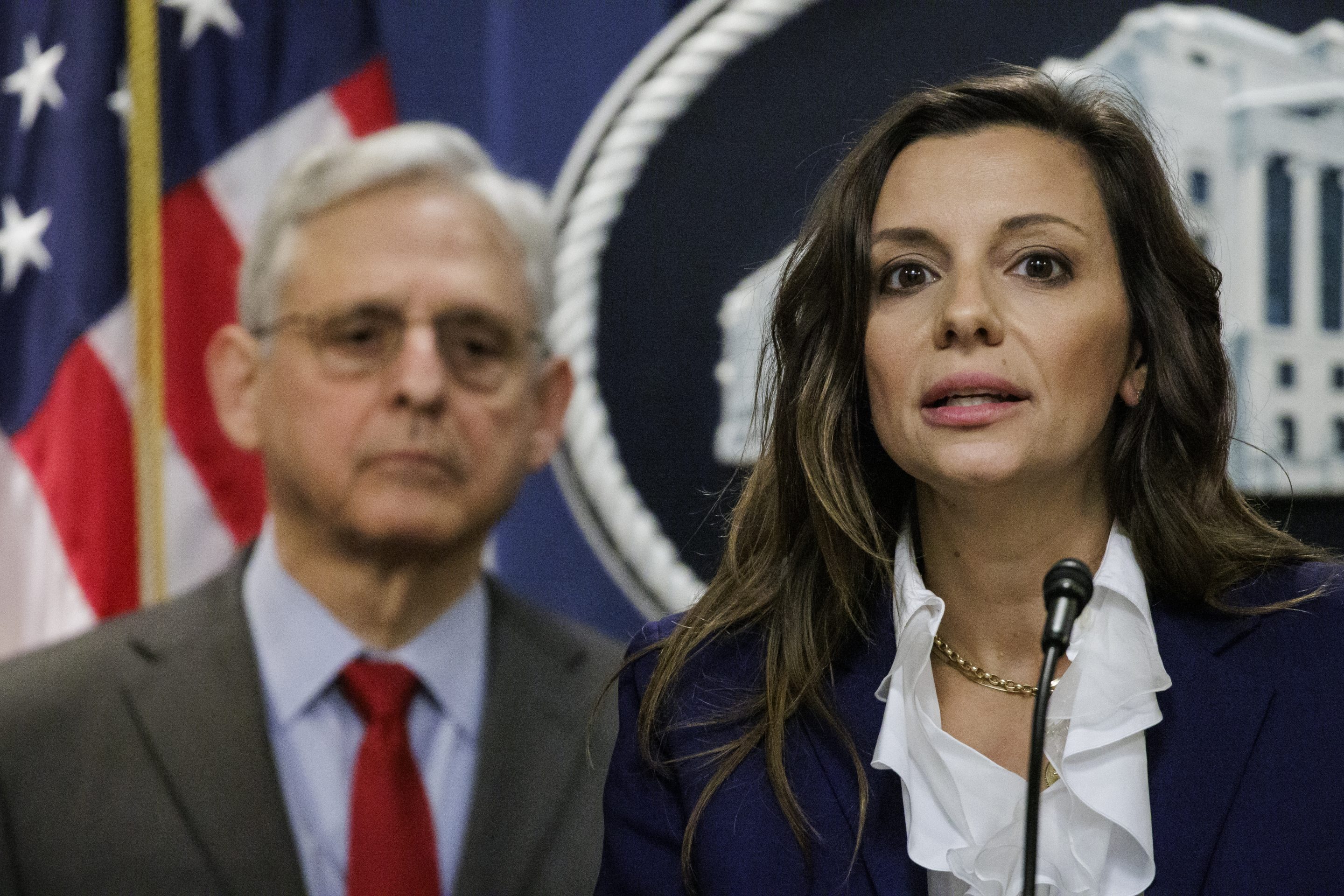Nicole Argentieri, the principal deputy assistant attorney general for the Criminal Division, stands in front of U.S. Attorney General Merrick Garland.