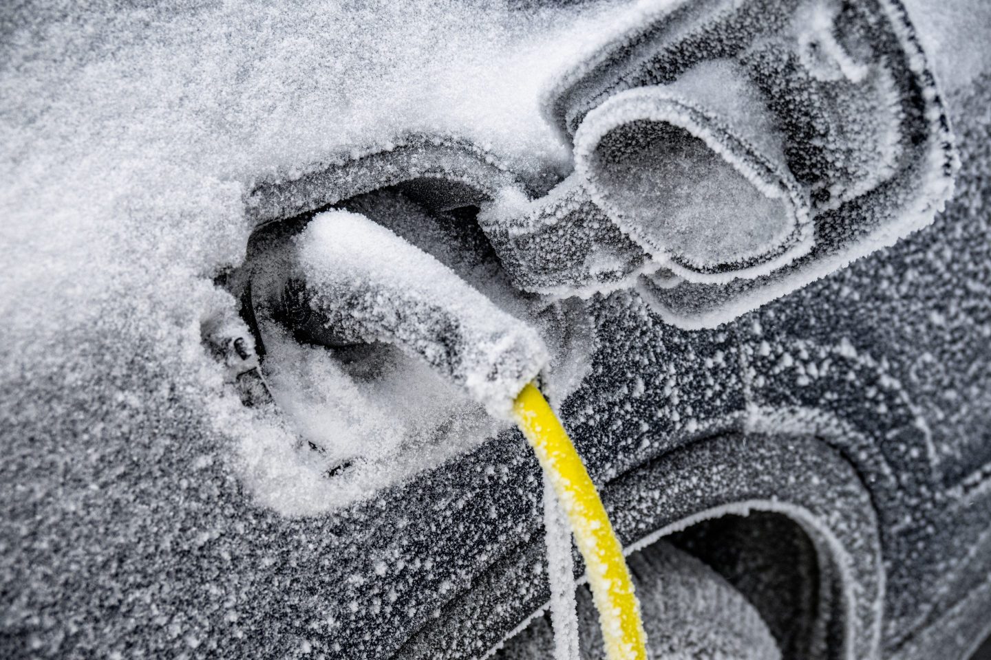 The electric car needs charging and is covered with ice