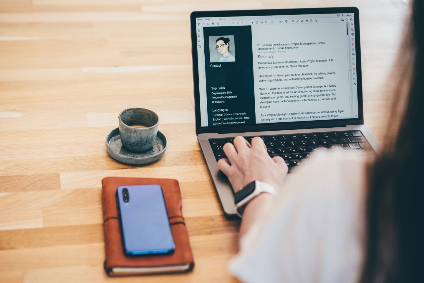 Person writing resume on laptop.