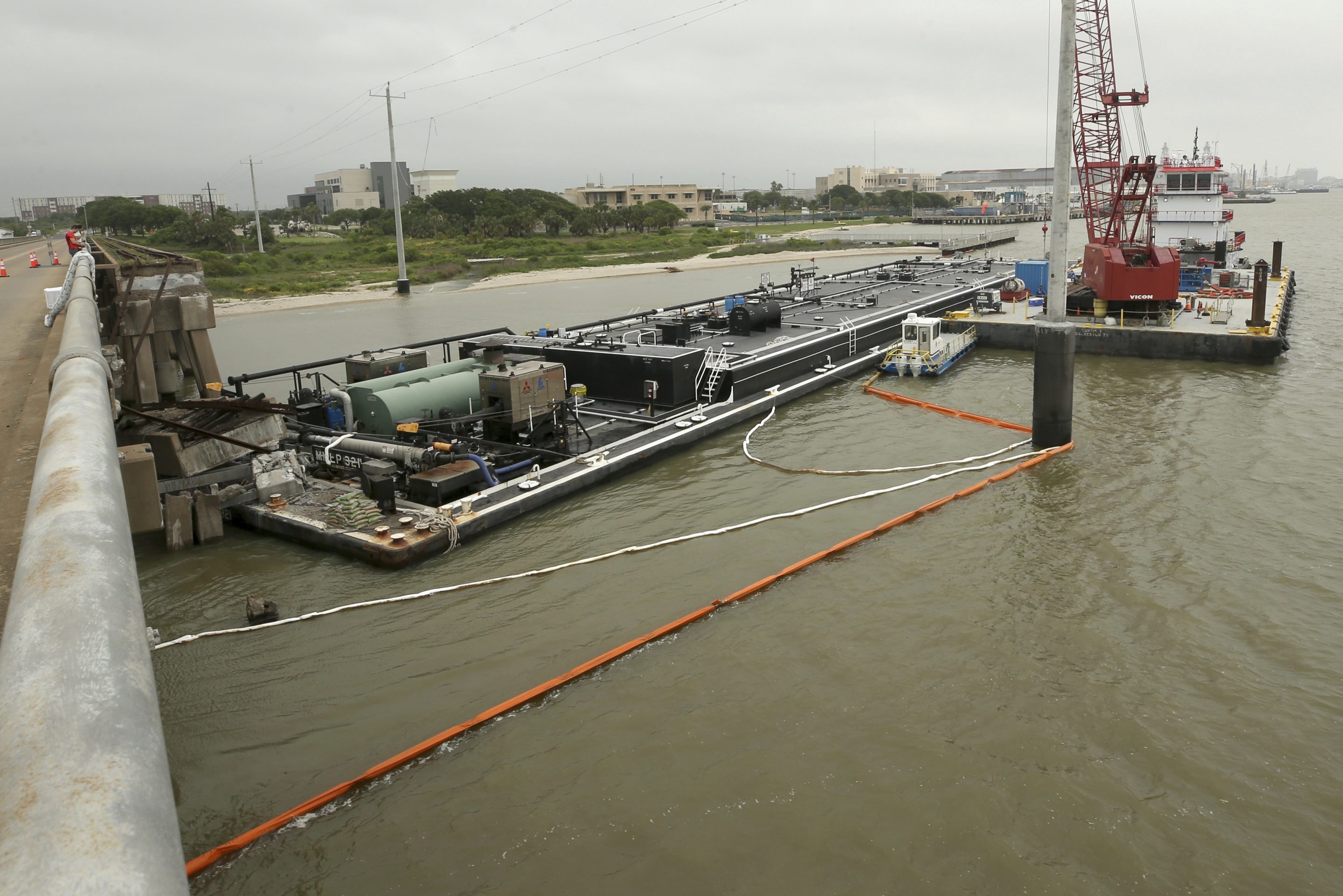 Spill booms surround a barge at the Pelican Island bridge in Galveston, Texas, on May 16, 2024.