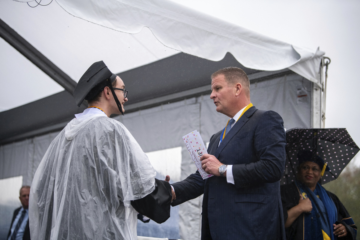 Billionaire Robert Hale, right, with a University of Massachusetts Dartmouth graduate student onstage at the graduation ceremony on May 16, 2024, in Dartmouth, Mass.