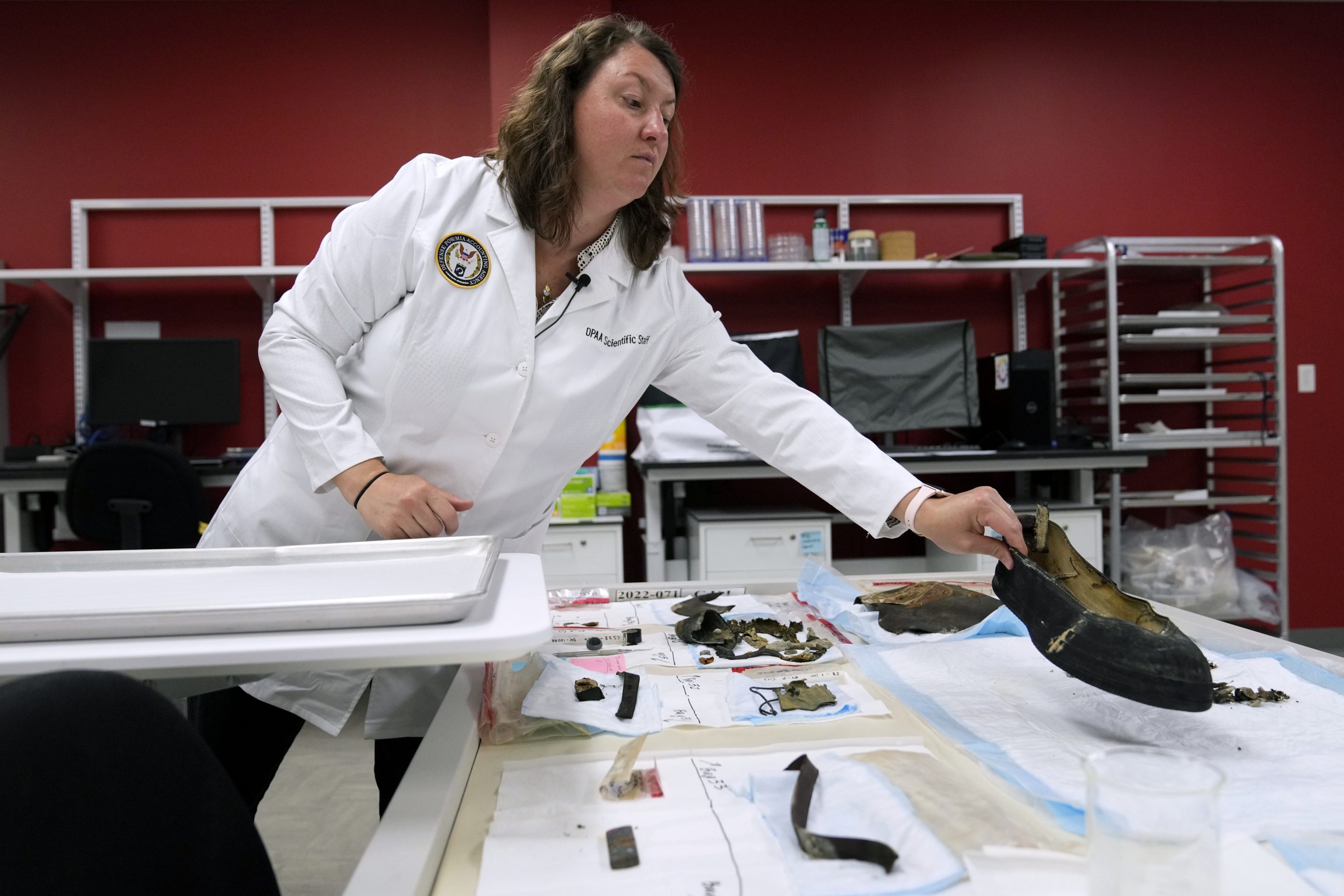 Defense POW/MIA Accounting Agency forensic anthropologist Carrie Brown looks at objects in a lab at Offutt Air Force Base, on May 20, 2024, in Bellevue, Neb.