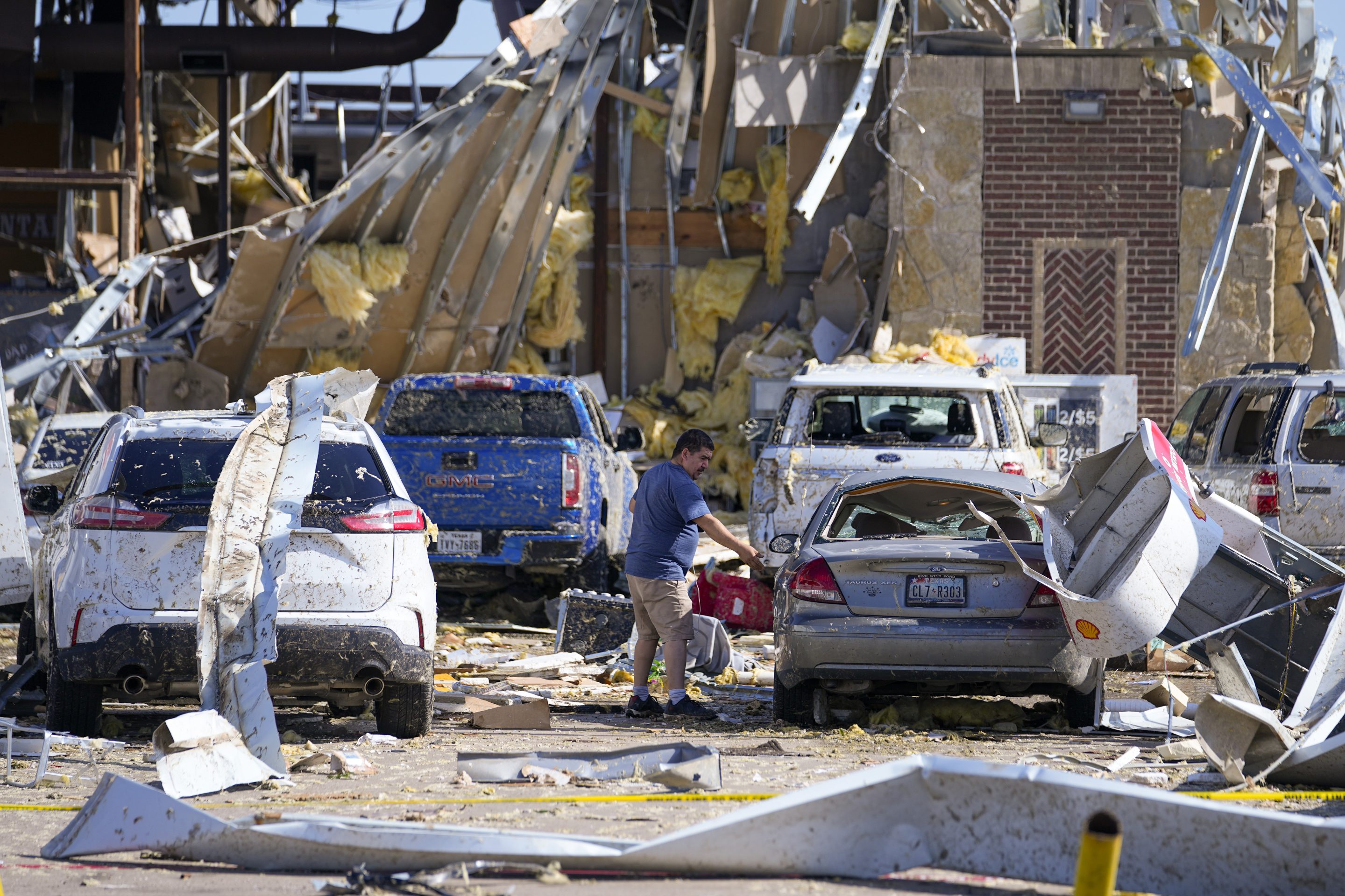 A man looks at a damaged car after a tornado hit the day before, on May 26, 2024, in Valley View, Texas.