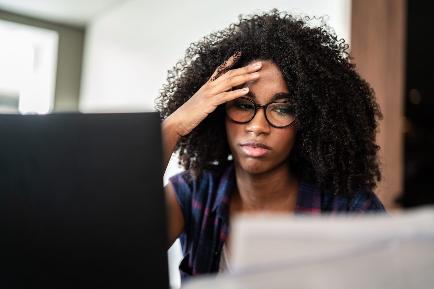 Gen Z worker looking worried at he computer