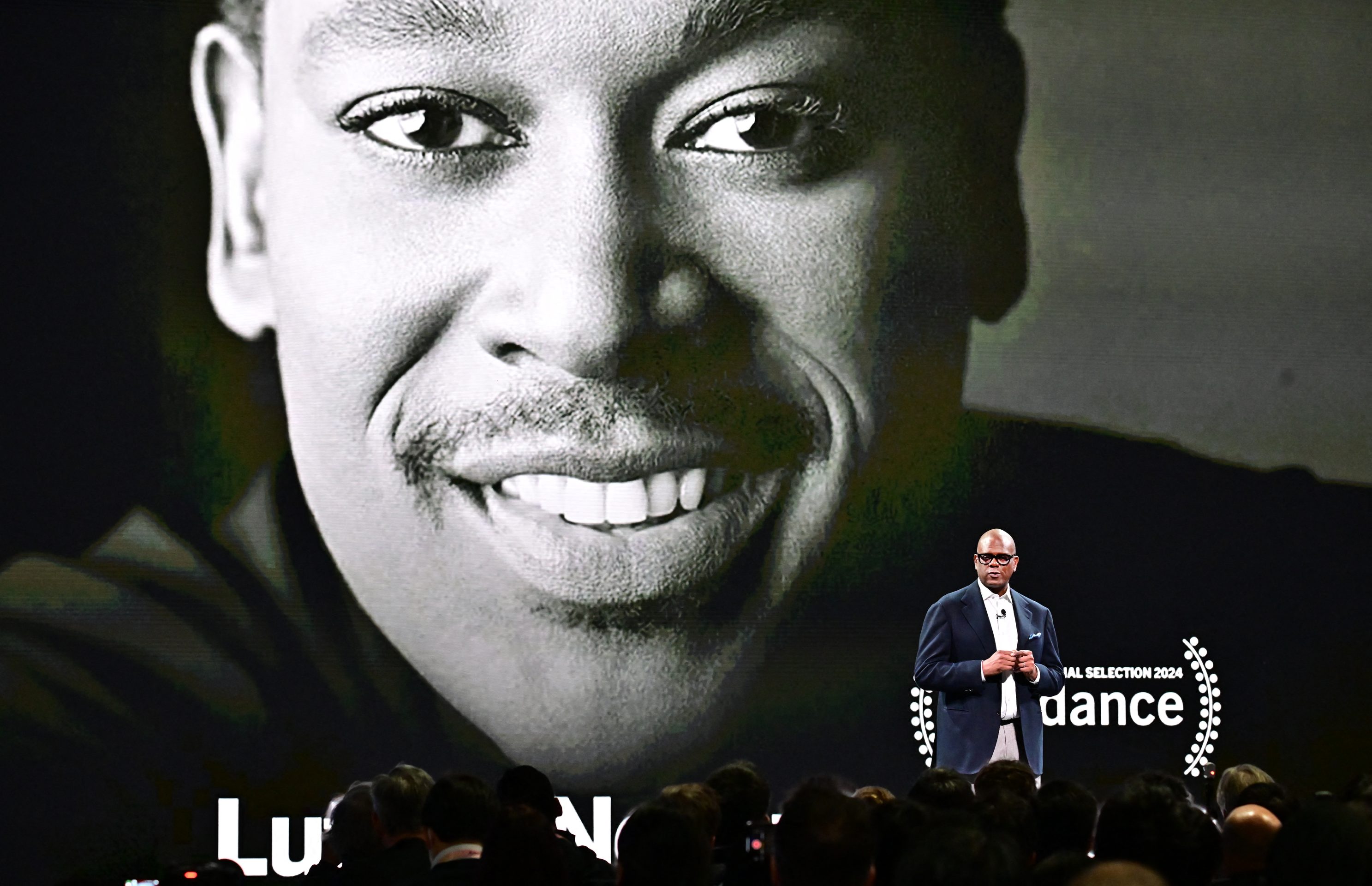 Jon Platt speaks in front of a poster