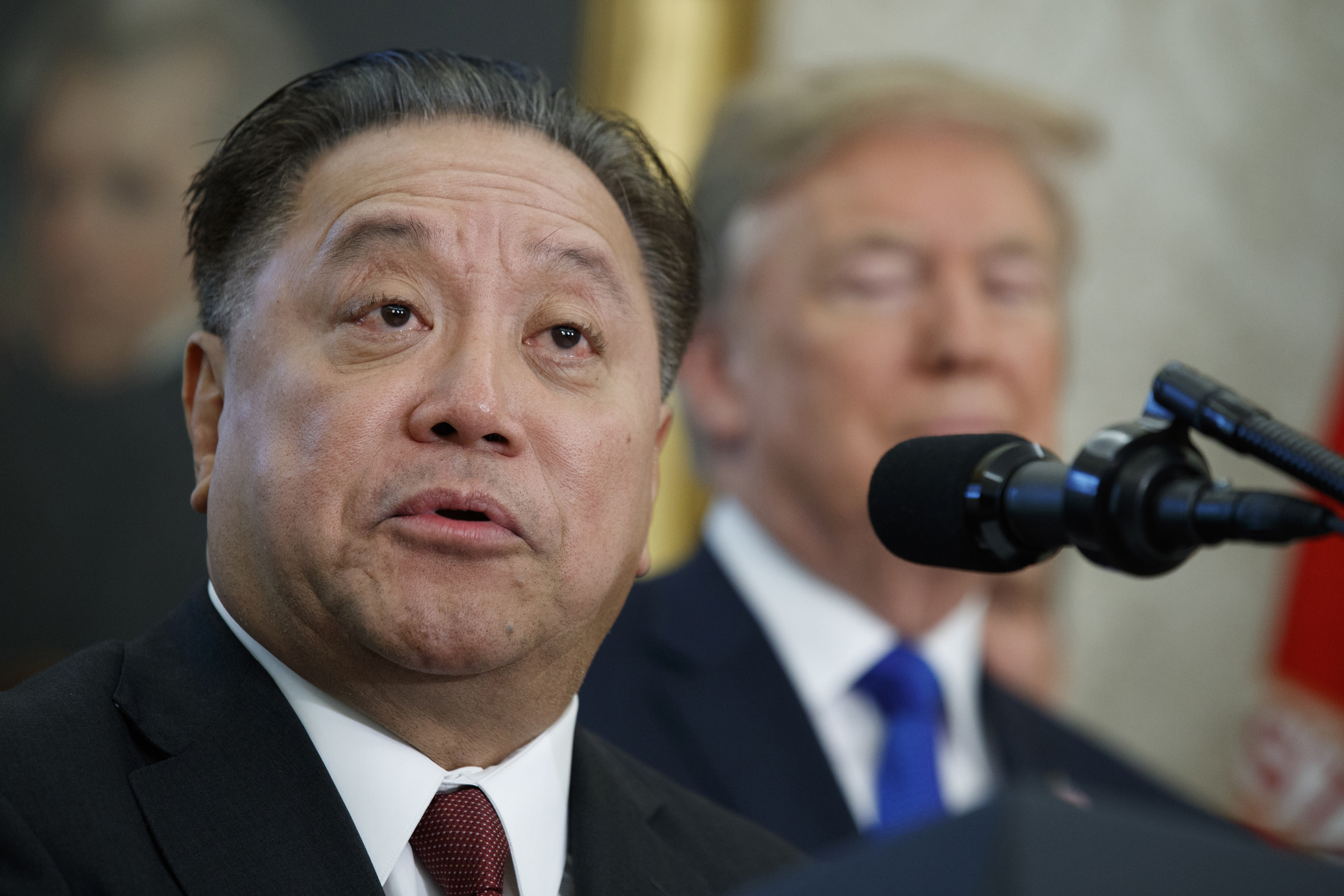 Broadcom CEO Hock Tan speaks as President Donald Trump listens during an event on Nov. 2, 2017 in Washington. Tan topped the AP survey of CEO pay with a package valued at about $162 million in 2023.