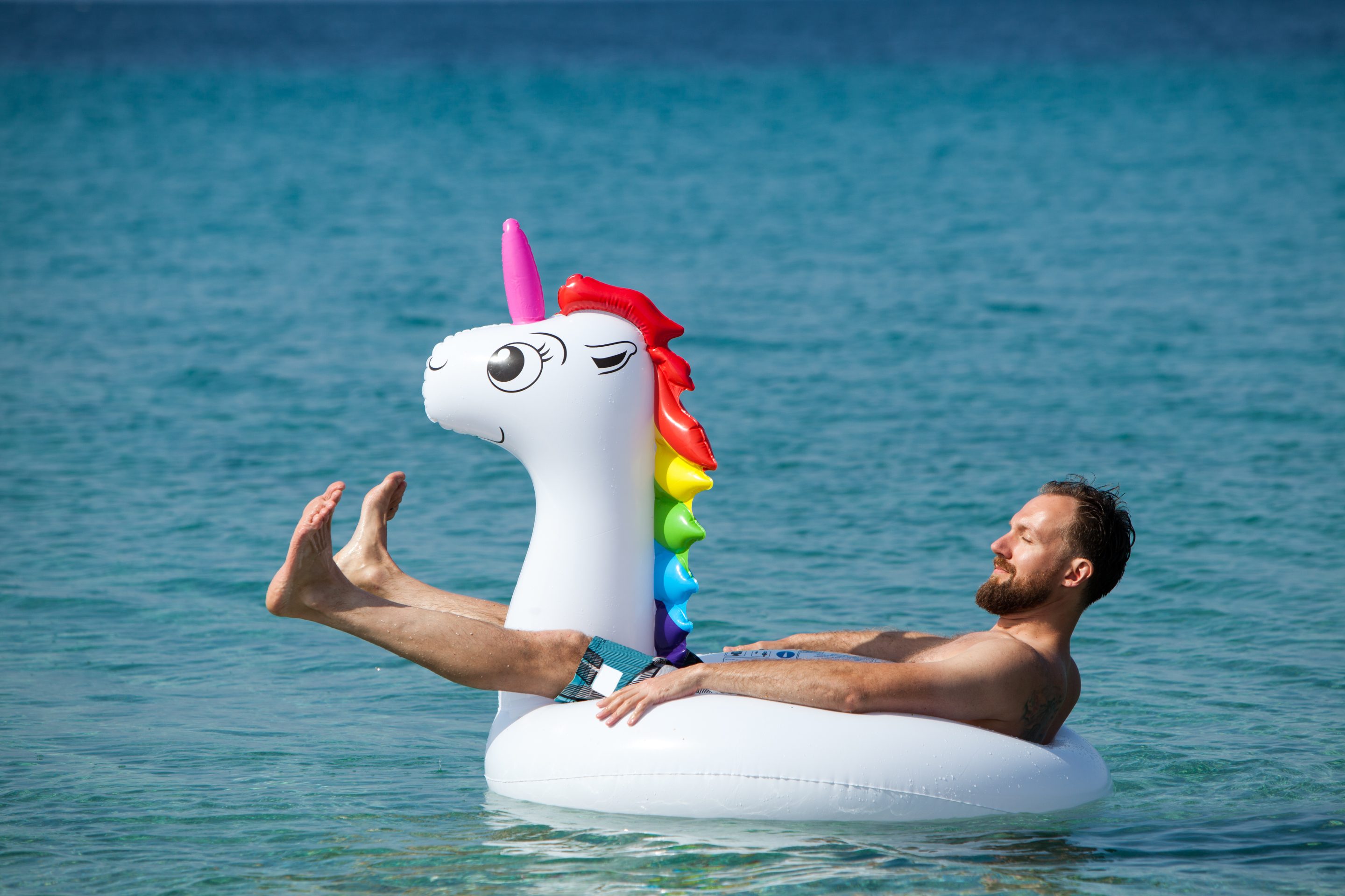 A man on a unicorn floatie.