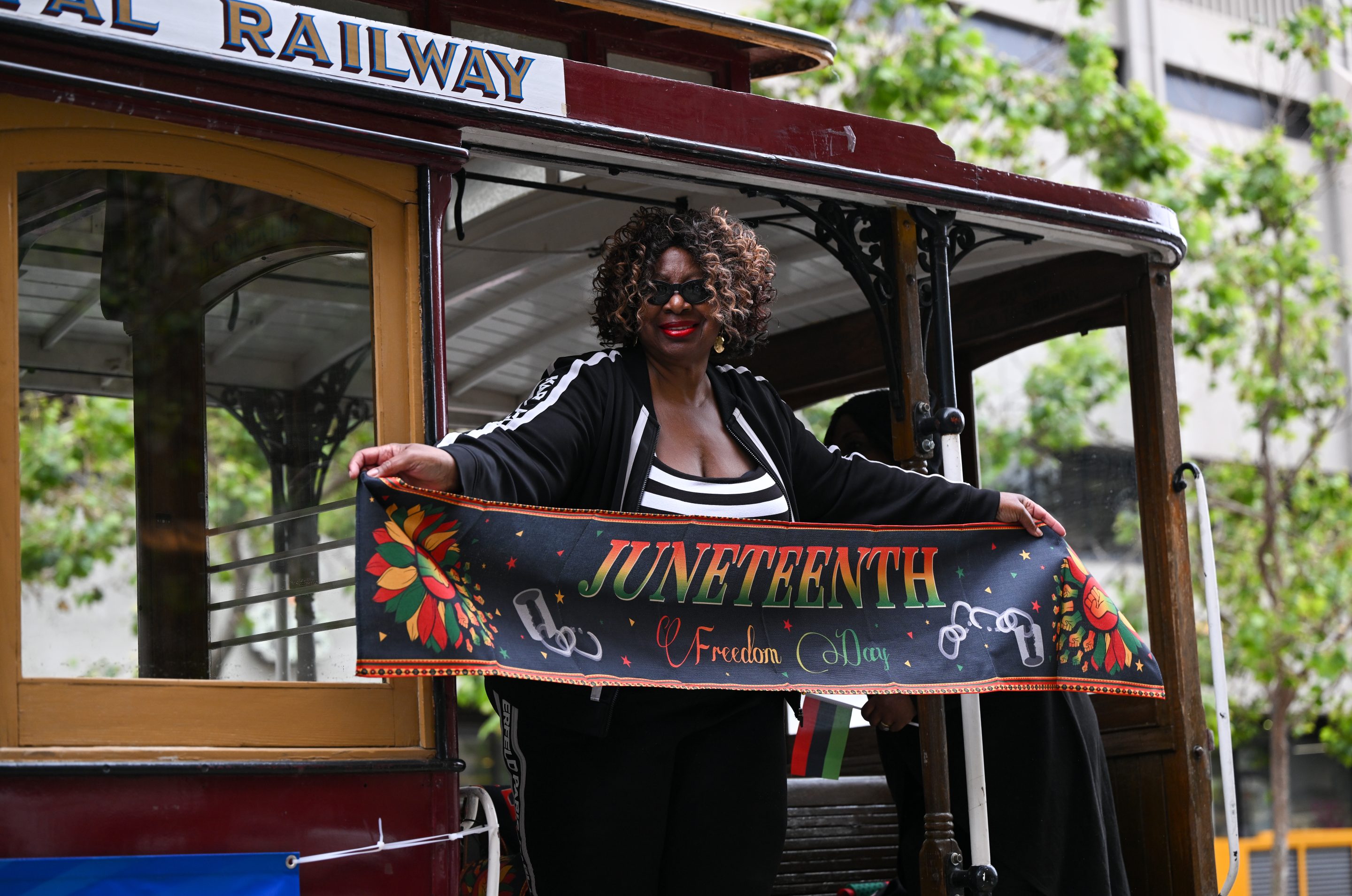 A woman holds a banner during Juneteenth celebration and parade in San Francisco.