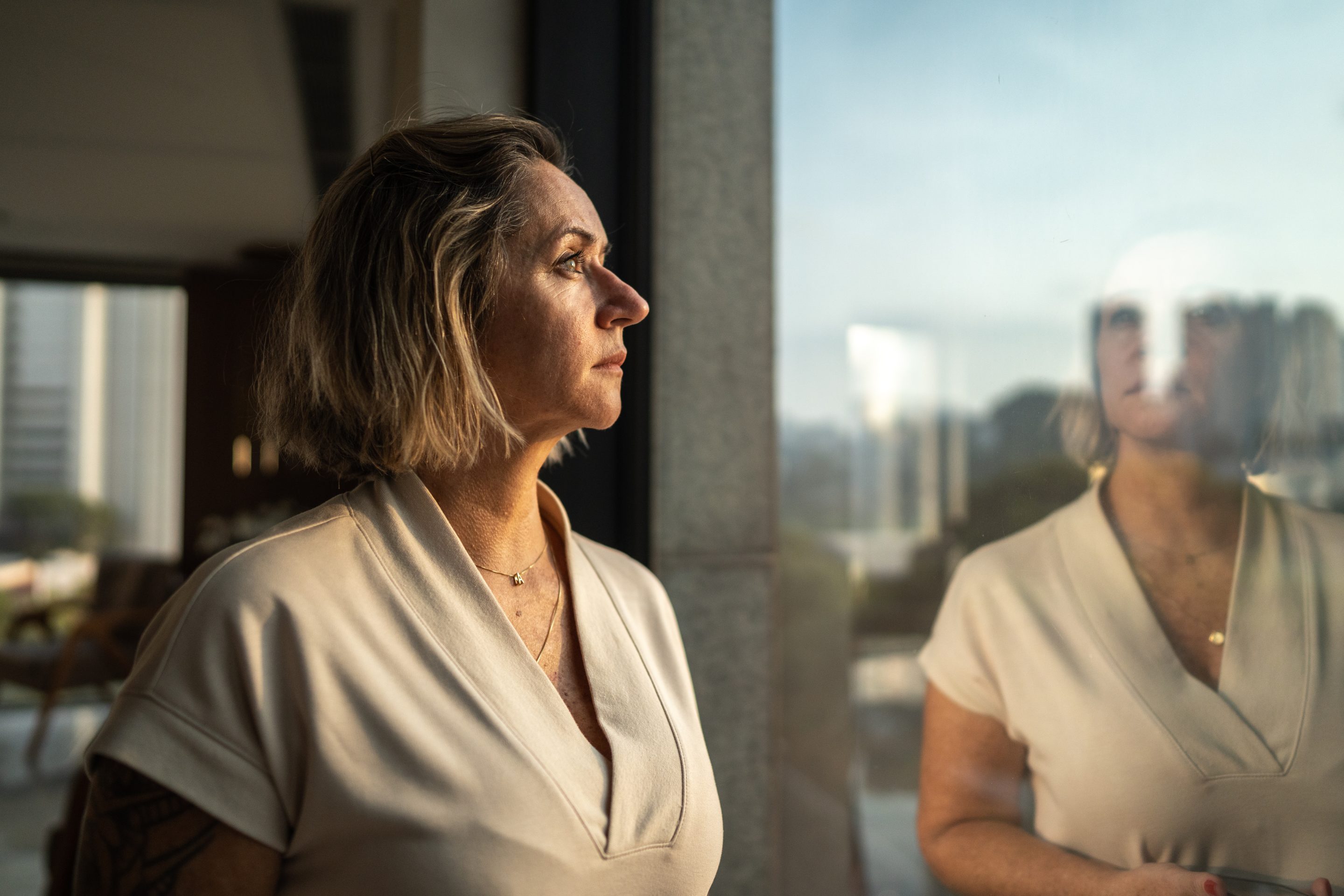 Contemplative woman looking through a window