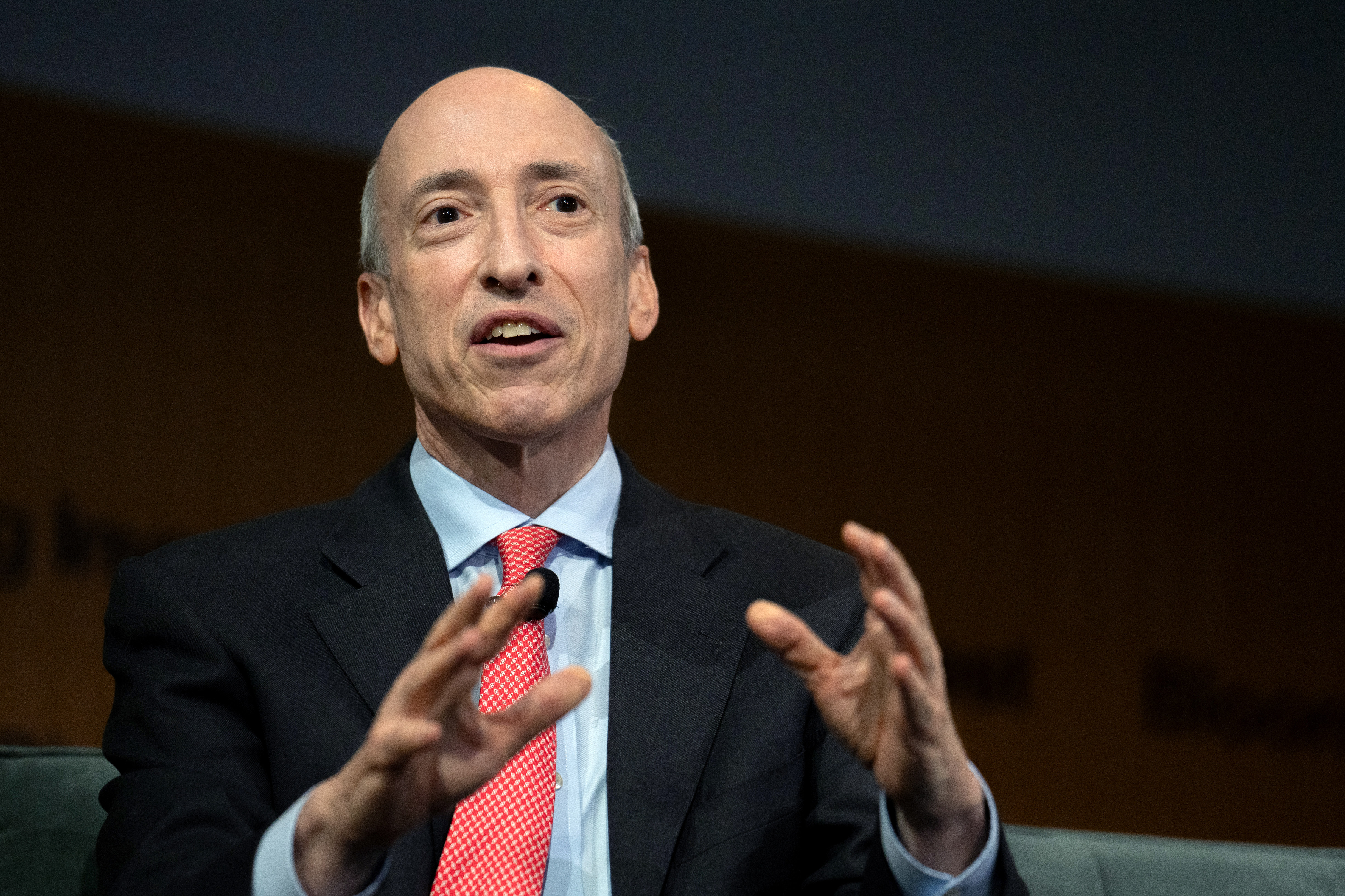 CFTC chairman Gary Gensler gestures with both hands while looking into the distance as he speaks.
