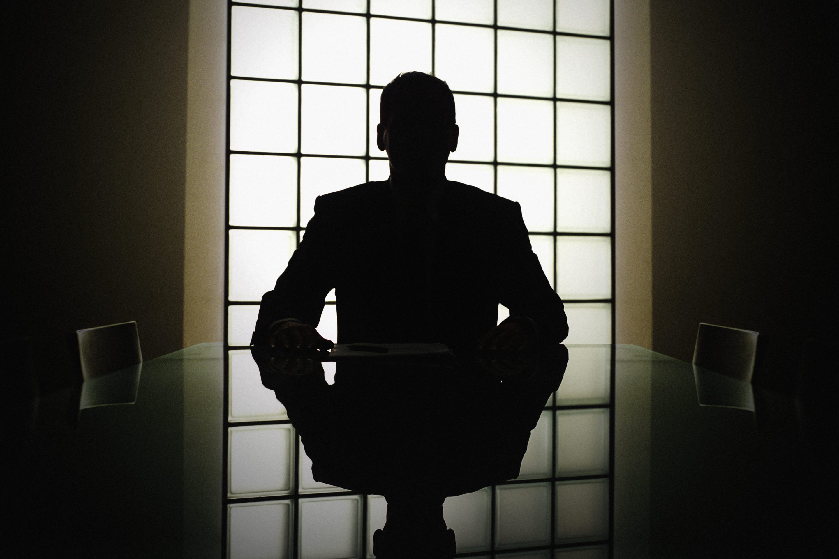 Silhouette of a man at a desk