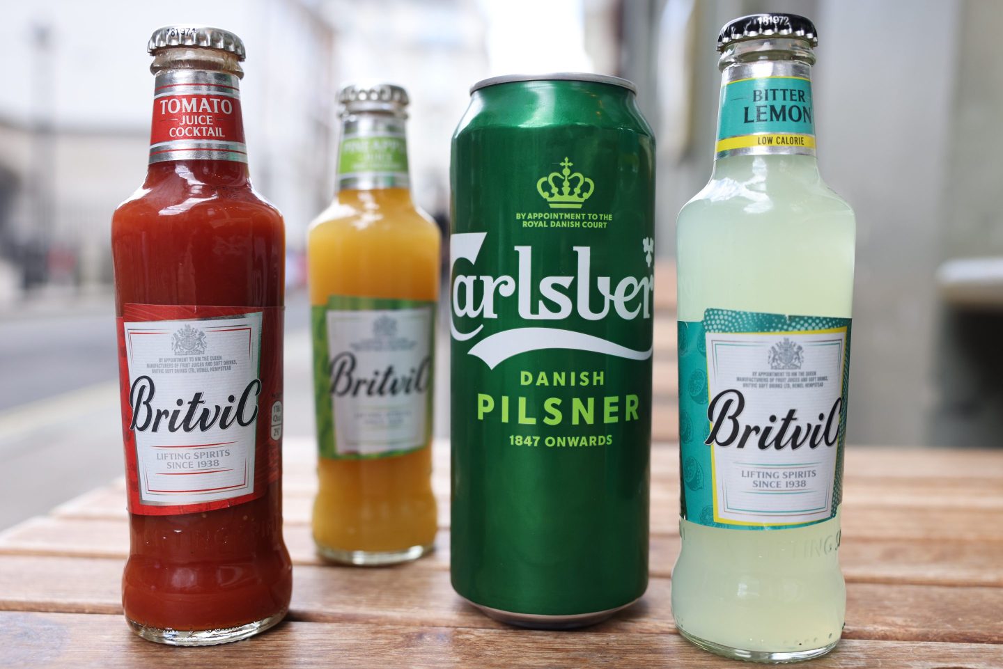 a row of 3 bottles and 1 can lined on a table