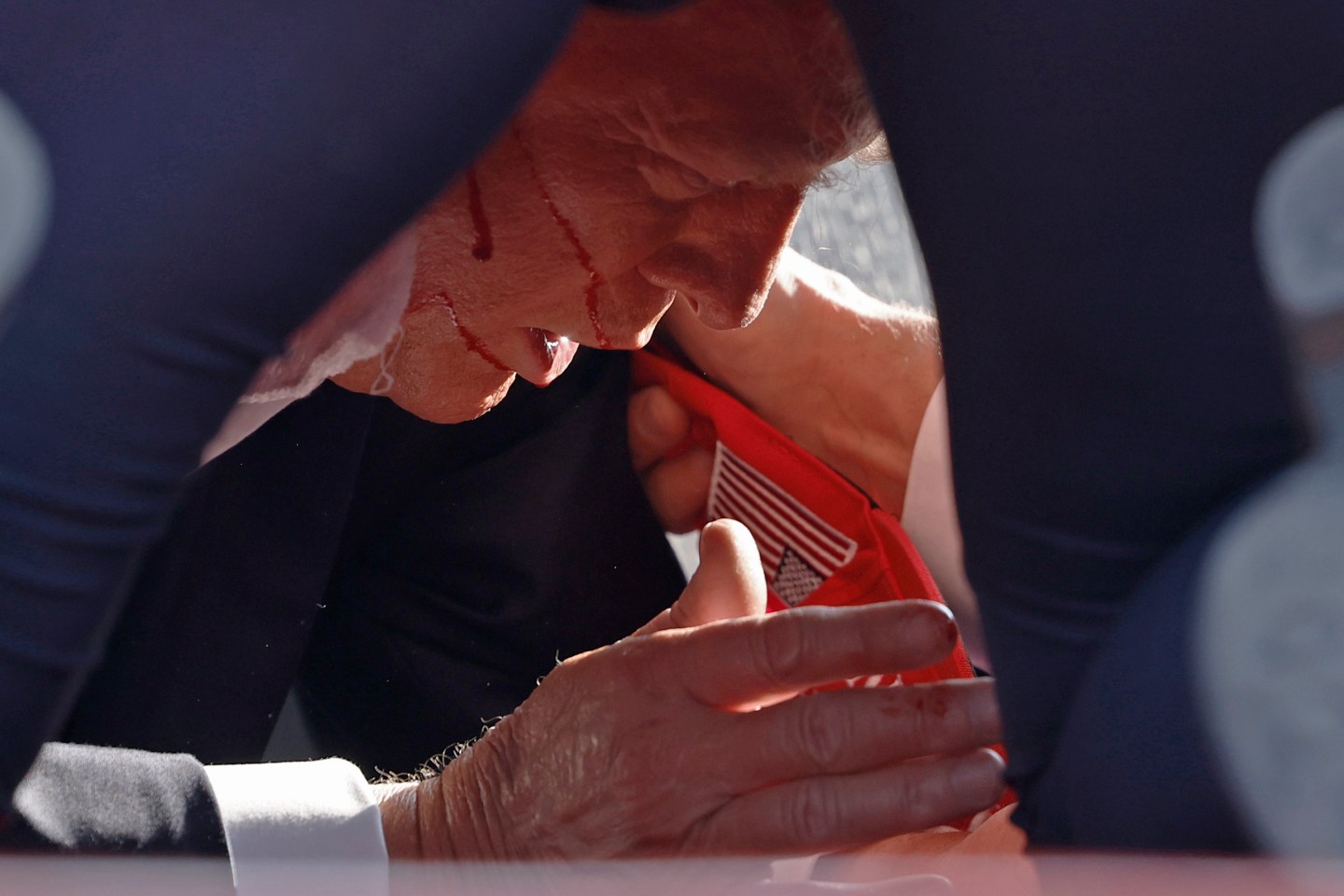 Former president Donald Trump lies on the ground bleeding.