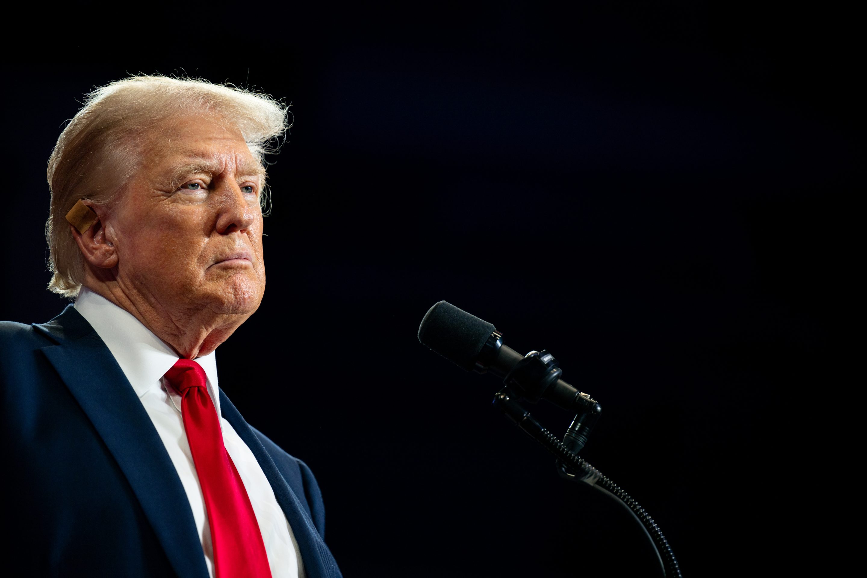 Donald Trump stands in front of a microphone