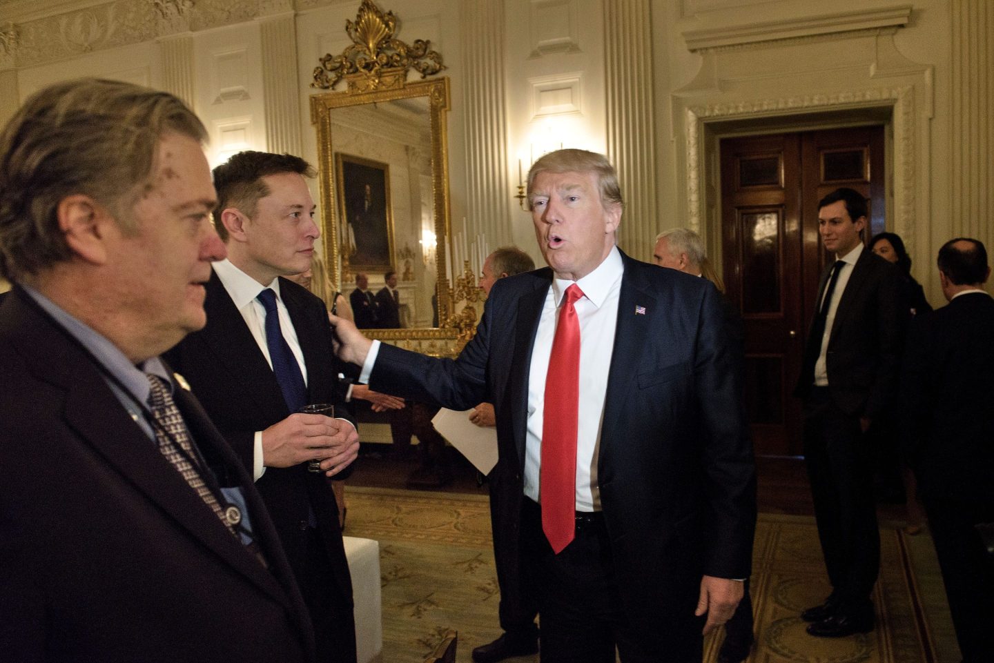 Trump advisor Steve Bannon (L) watches as US President Donald Trump greets Elon Musk, SpaceX and Tesla CEO, before a policy and strategy forum with executives in the State Dining Room of the White House February 3, 2017