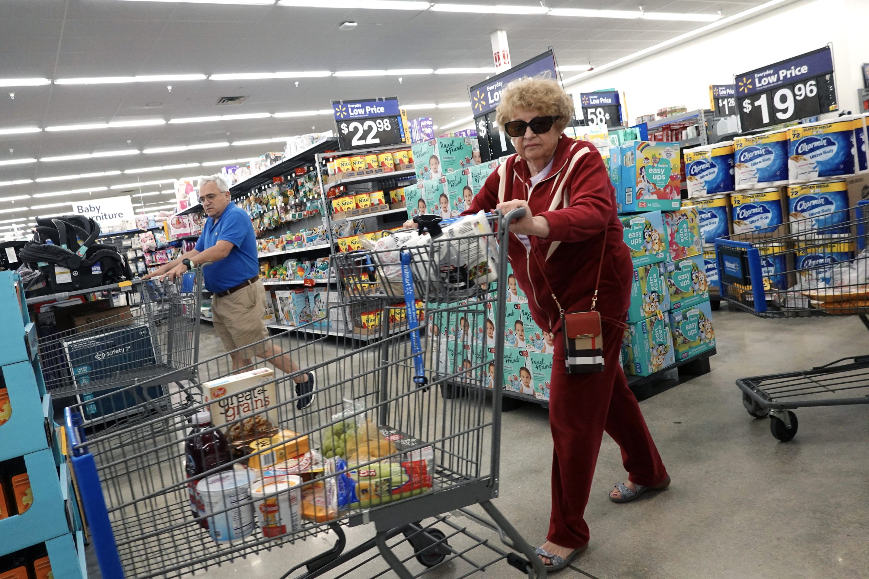 A woman pushing a shopping cart in a Walmart
