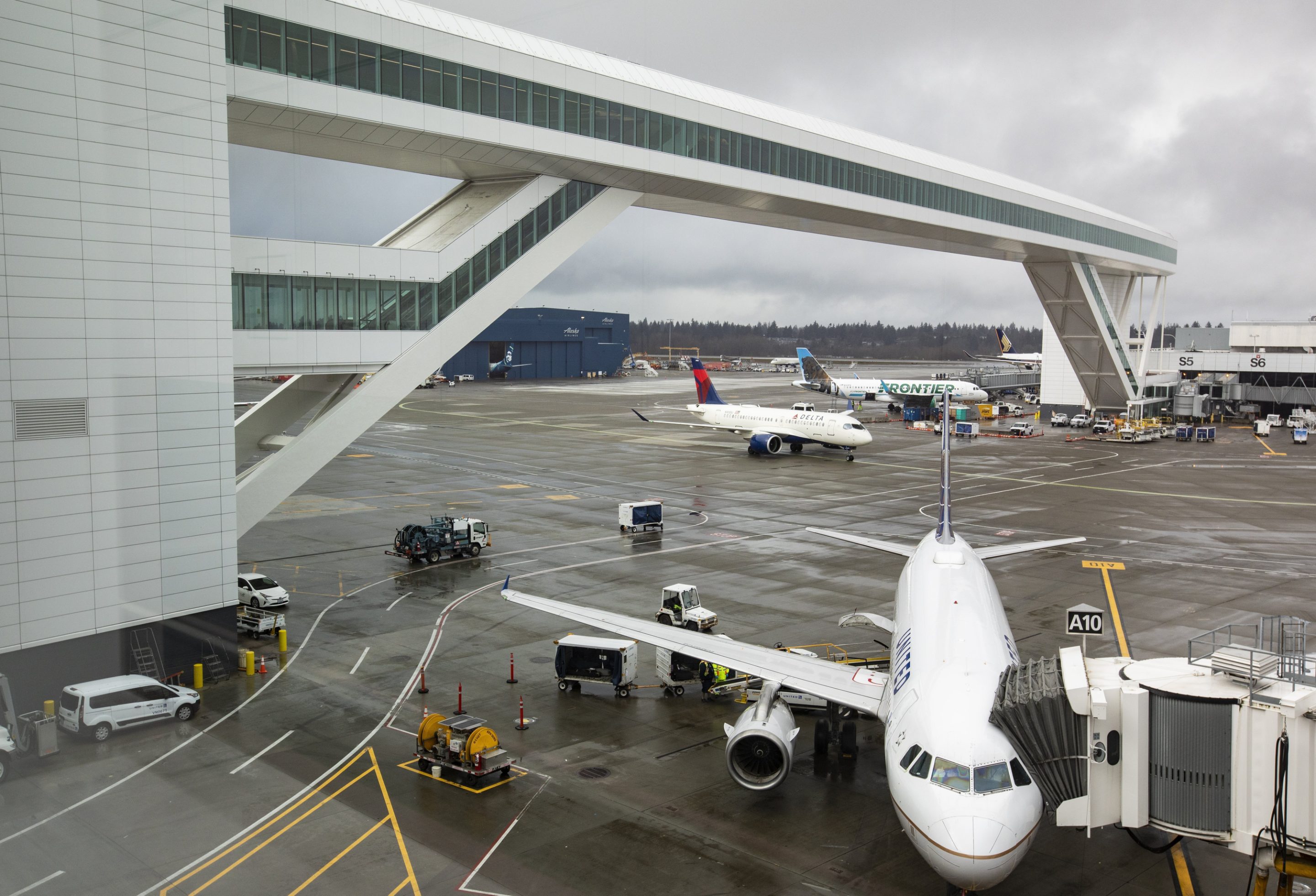Planes taxi under the aerial passenger walkway at Seattle-Tacoma International Airport, March 3, 2022, in Seattle.