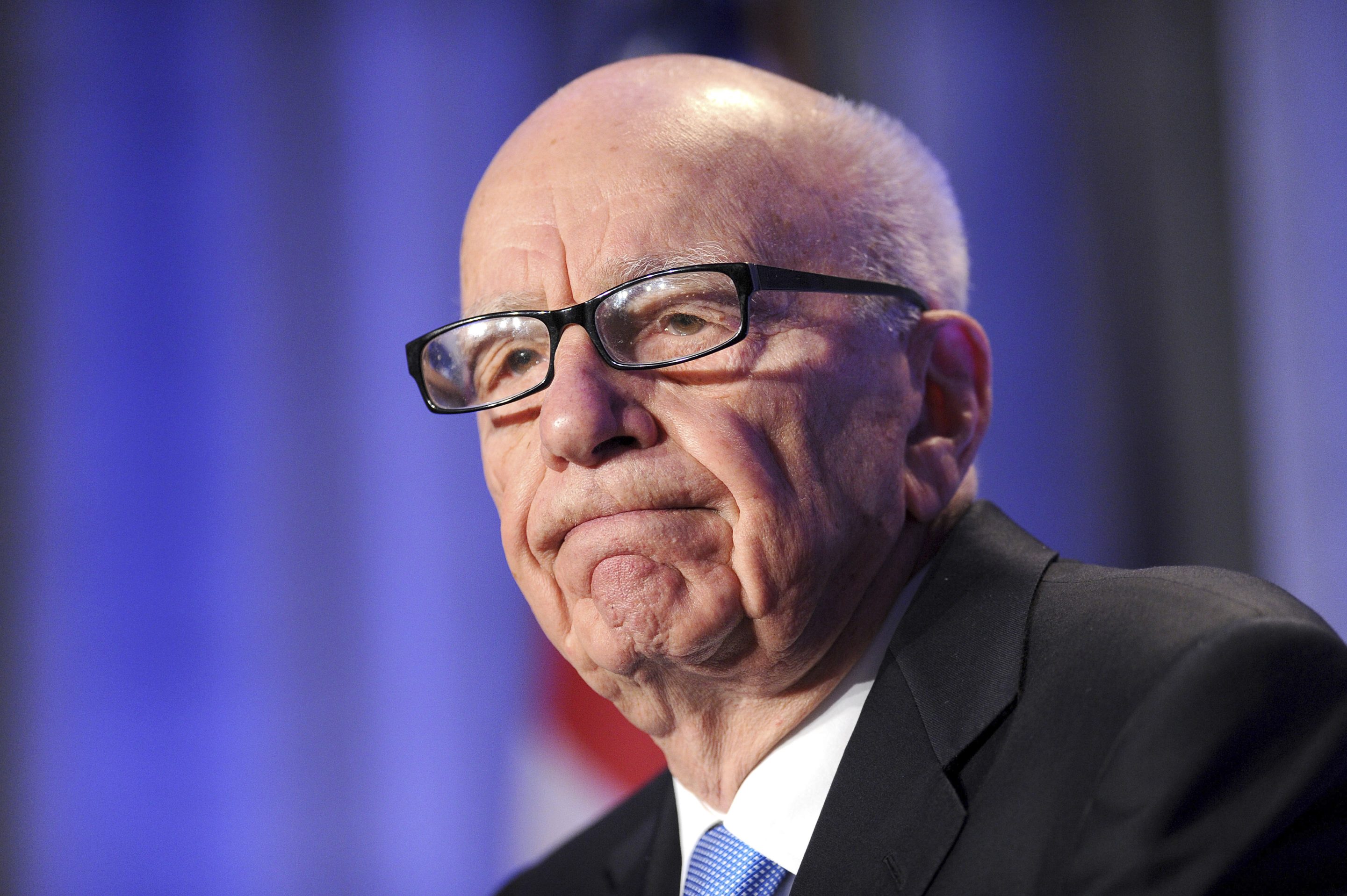 News Corp. CEO Rupert Murdoch is seen at an event wearing a suit and glasses.