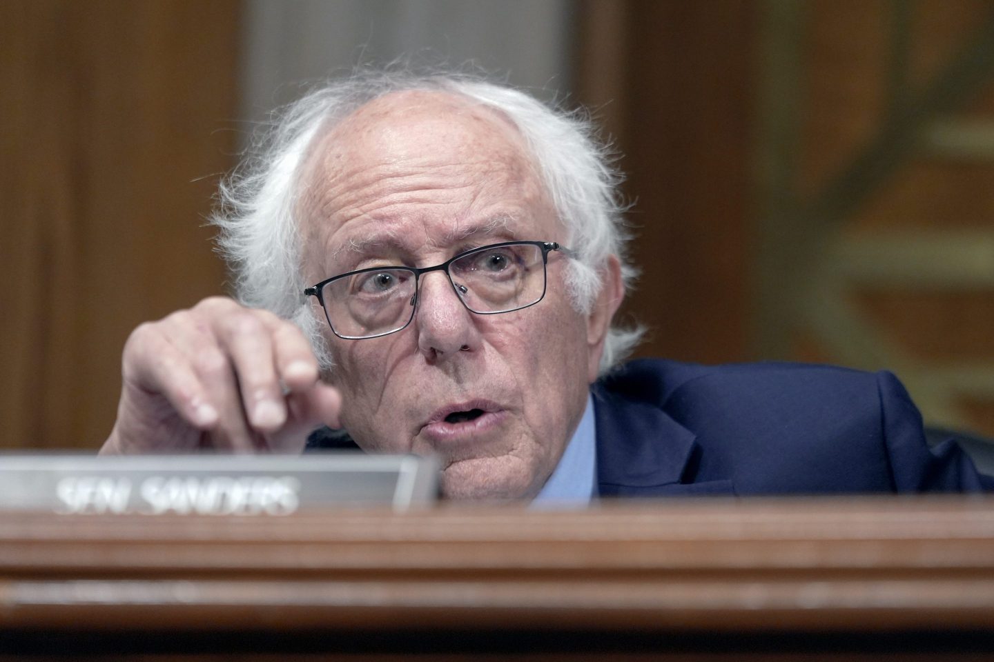 Sen. Bernie Sanders, I-Vt., speaks during a Senate Health, Education, Labor, and Pensions Committee business meeting. He is behind his name plate at a long desk and is gesturing with his right hand.