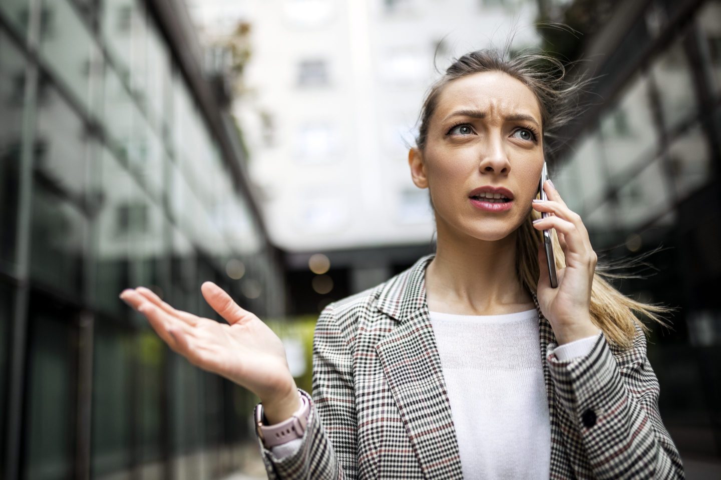 Angry-looking woman using her cell phone while walking