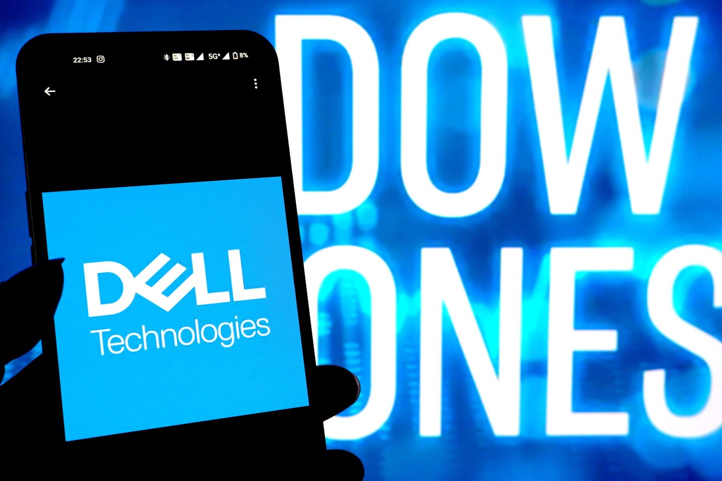 A Dell Technologies logo seen displayed on a smartphone with Dow Jones logo in the background.