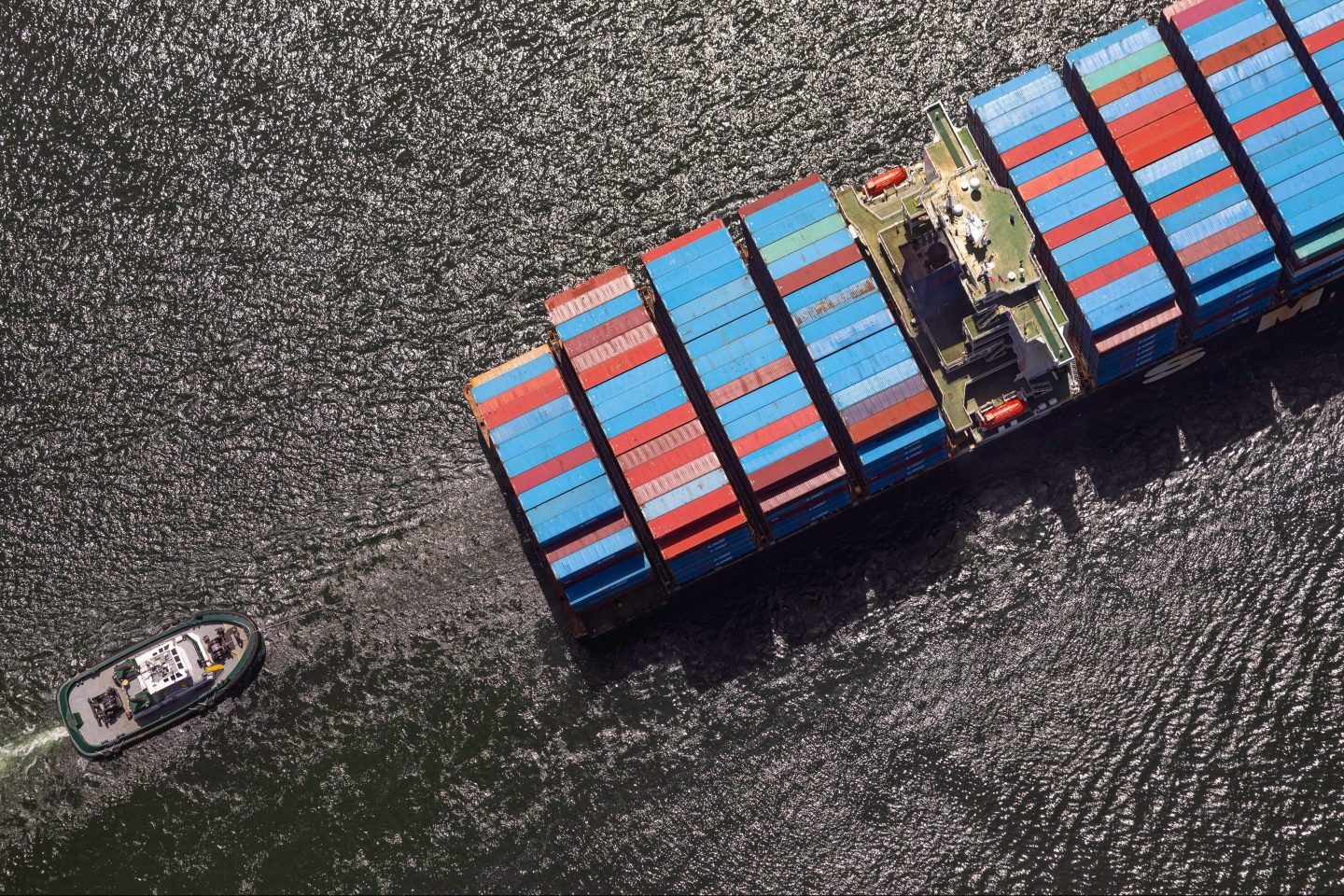 A photograph of a tug boat assisting a container ship to its berth at the Port of Long Beach in Long Beach, California, US, on Monday, June 17, 2024.