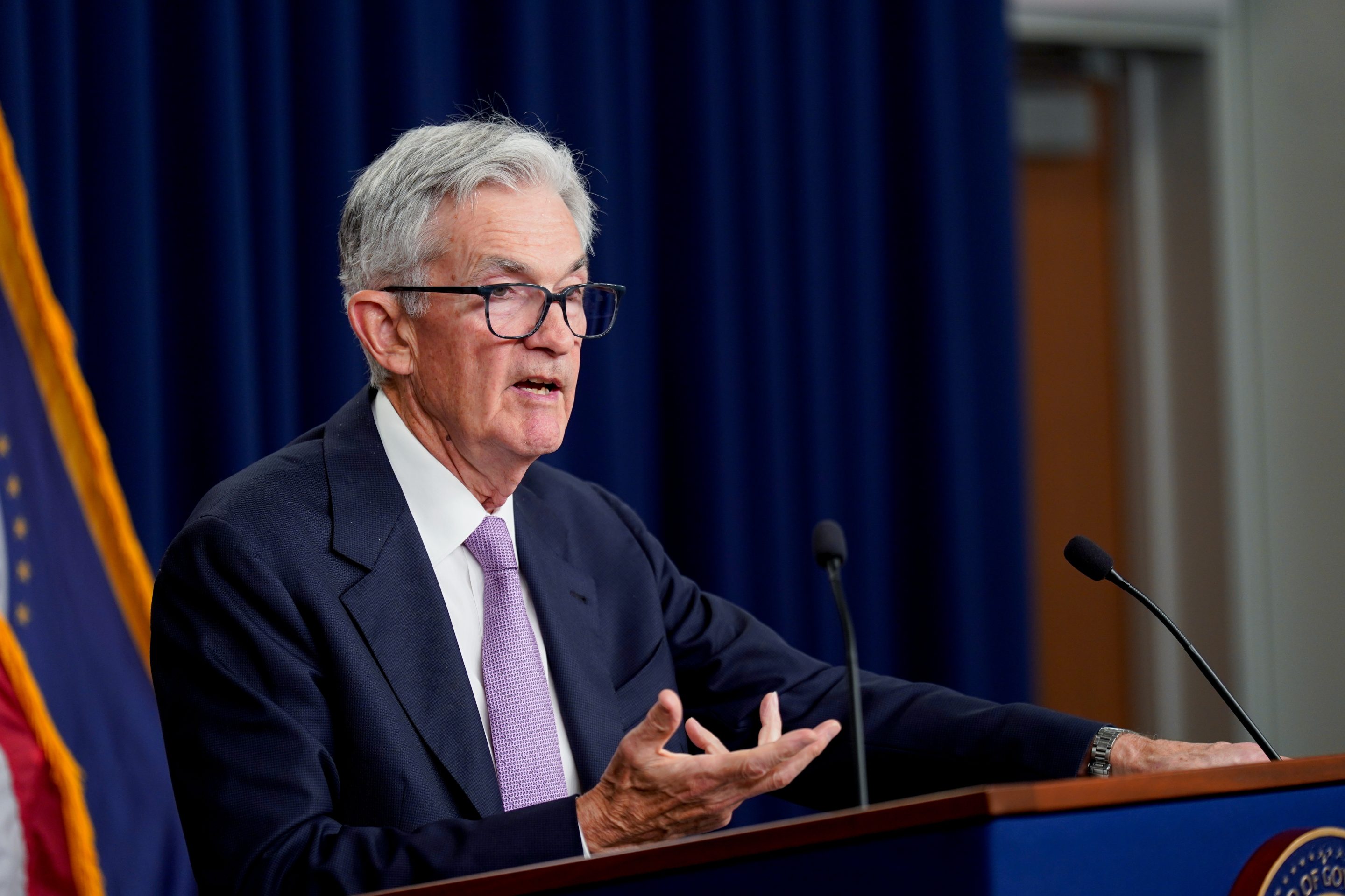 Fed chair Jerome Powell motions with his right hand as he speaks at a podium.
