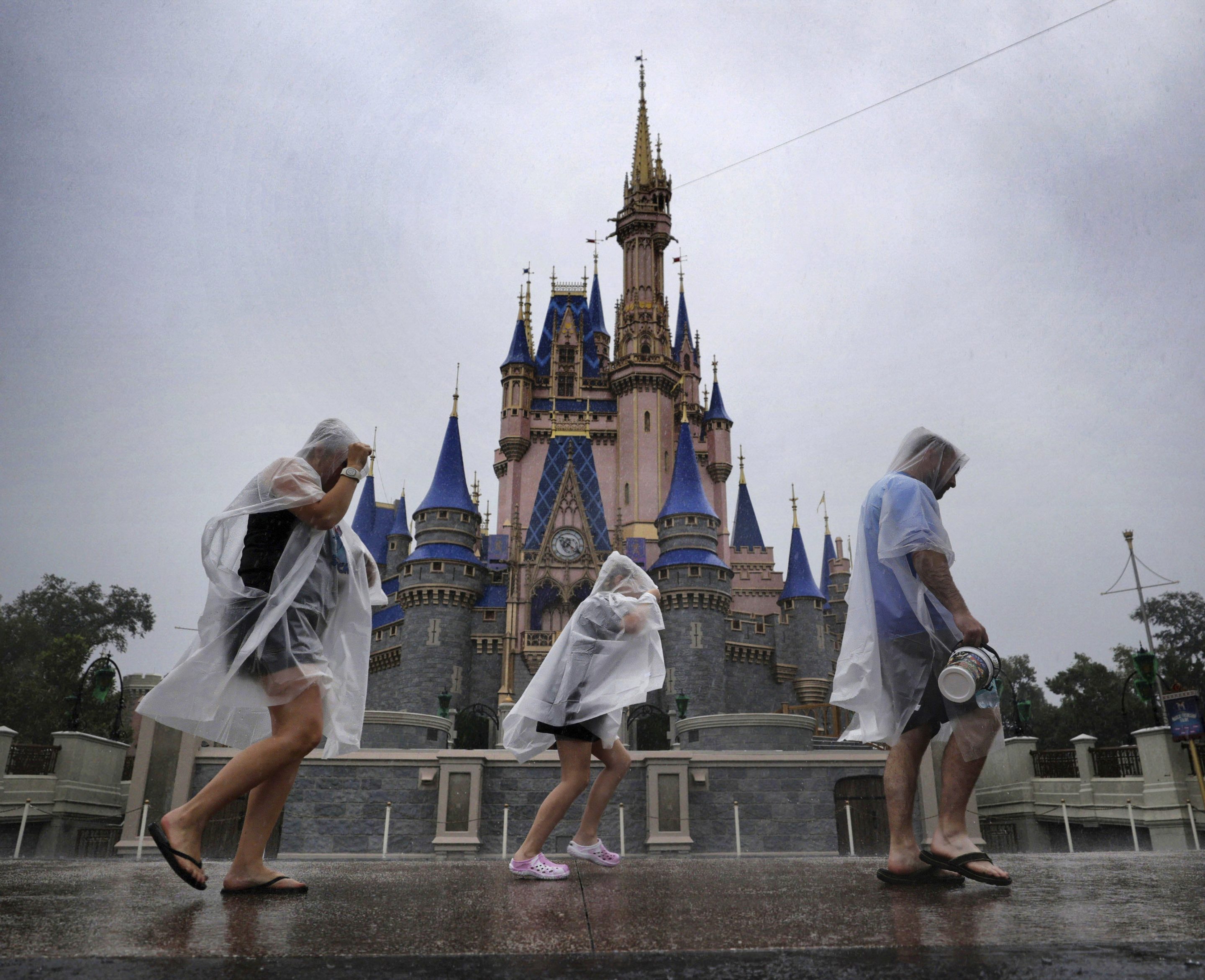 Guests weather early bands of rain from Hurricane Milton at the Magic Kingdom at Walt Disney World in Bay Lake, Fla., on Oct. 9, 2024. 