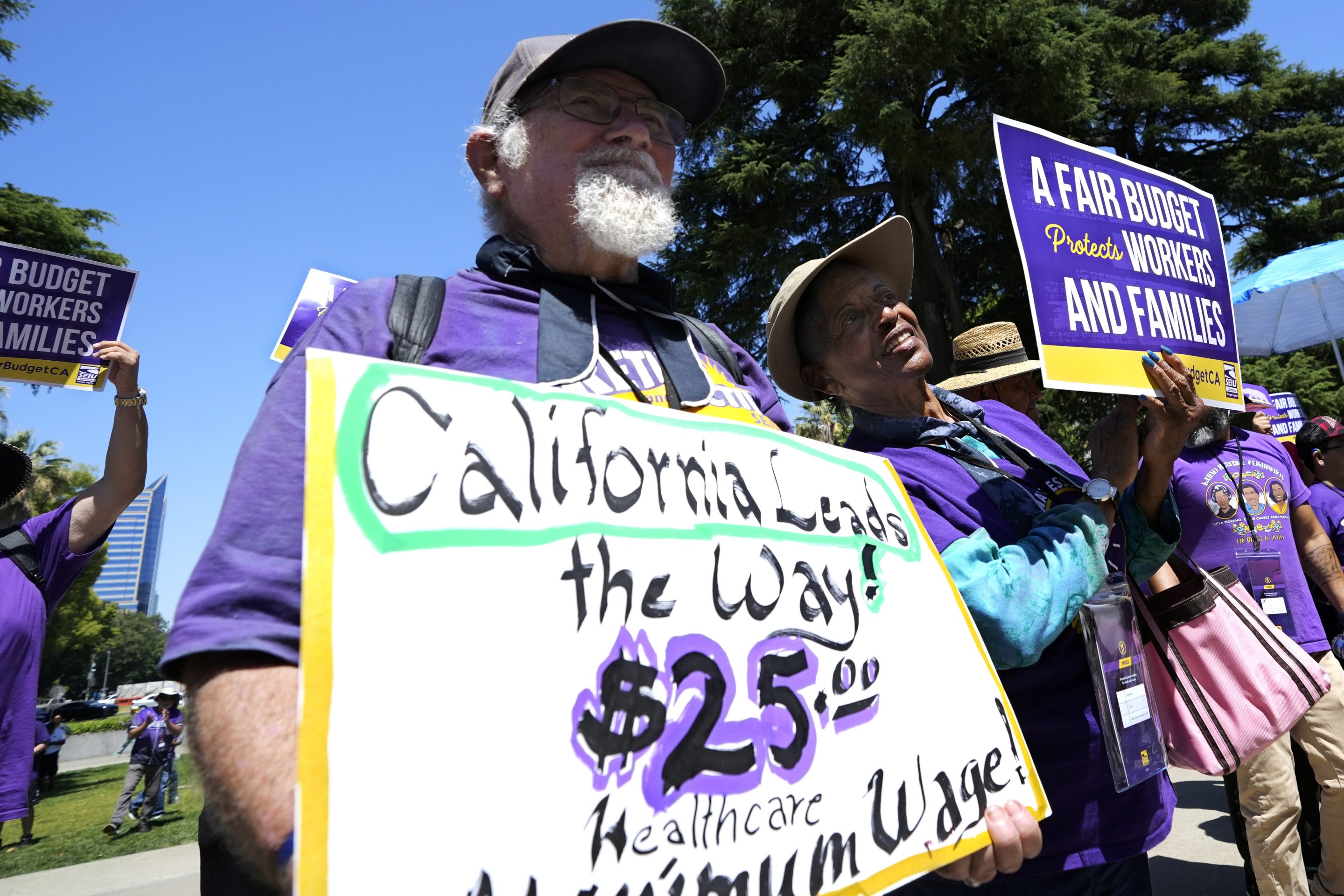 Retirees Ron Martin, left, and Willie Mae Hampton, right, join other supporters of the Service Employees International Union at a rally against proposed budget cuts to state provided social safety net programs, in Sacramento, on June 11, 2024.