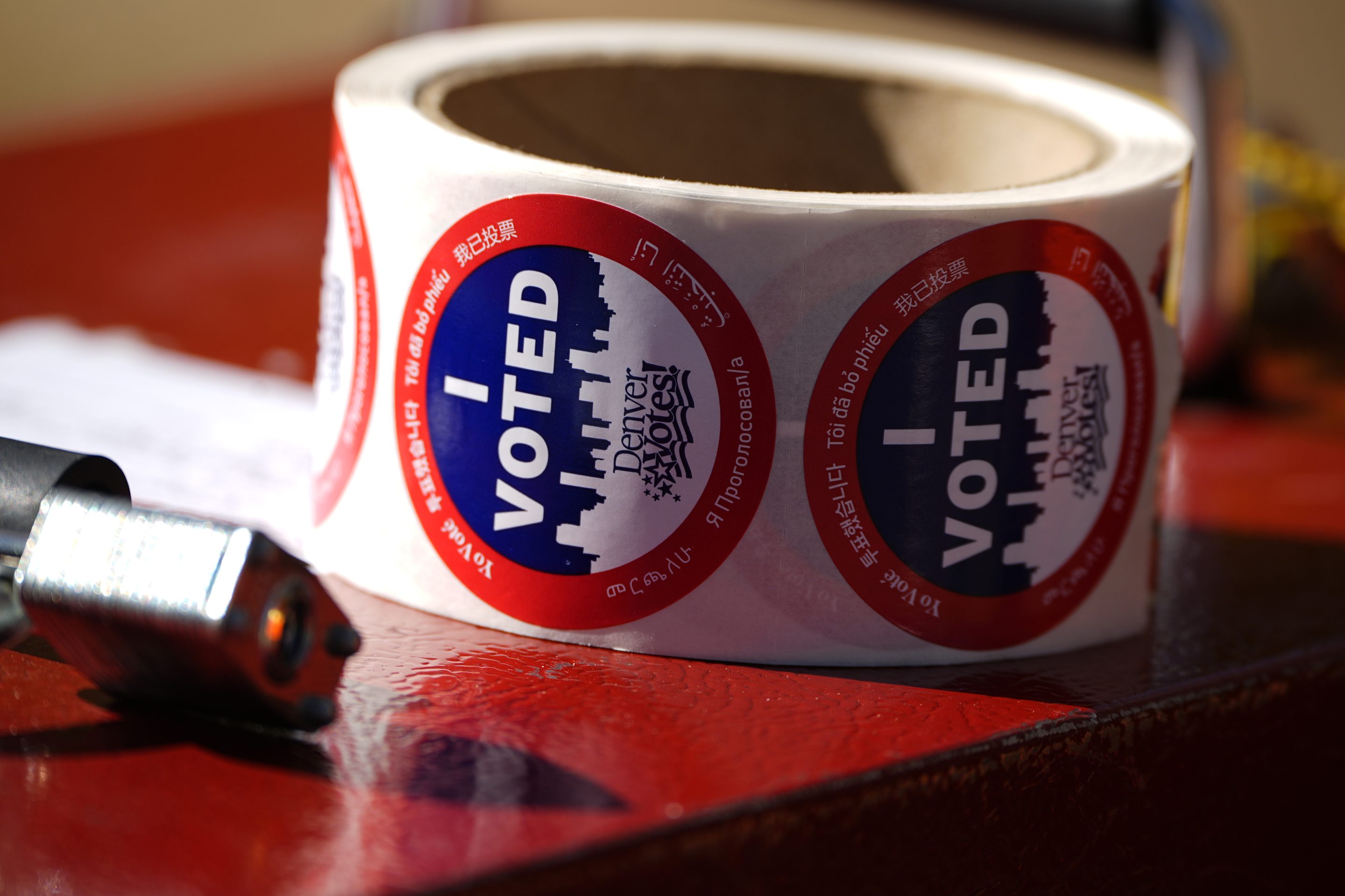 Stickers for voters sit in a roll on a ballot box at a voting drop-off location on Oct. 25, 2024, in Washington Park in Denver.