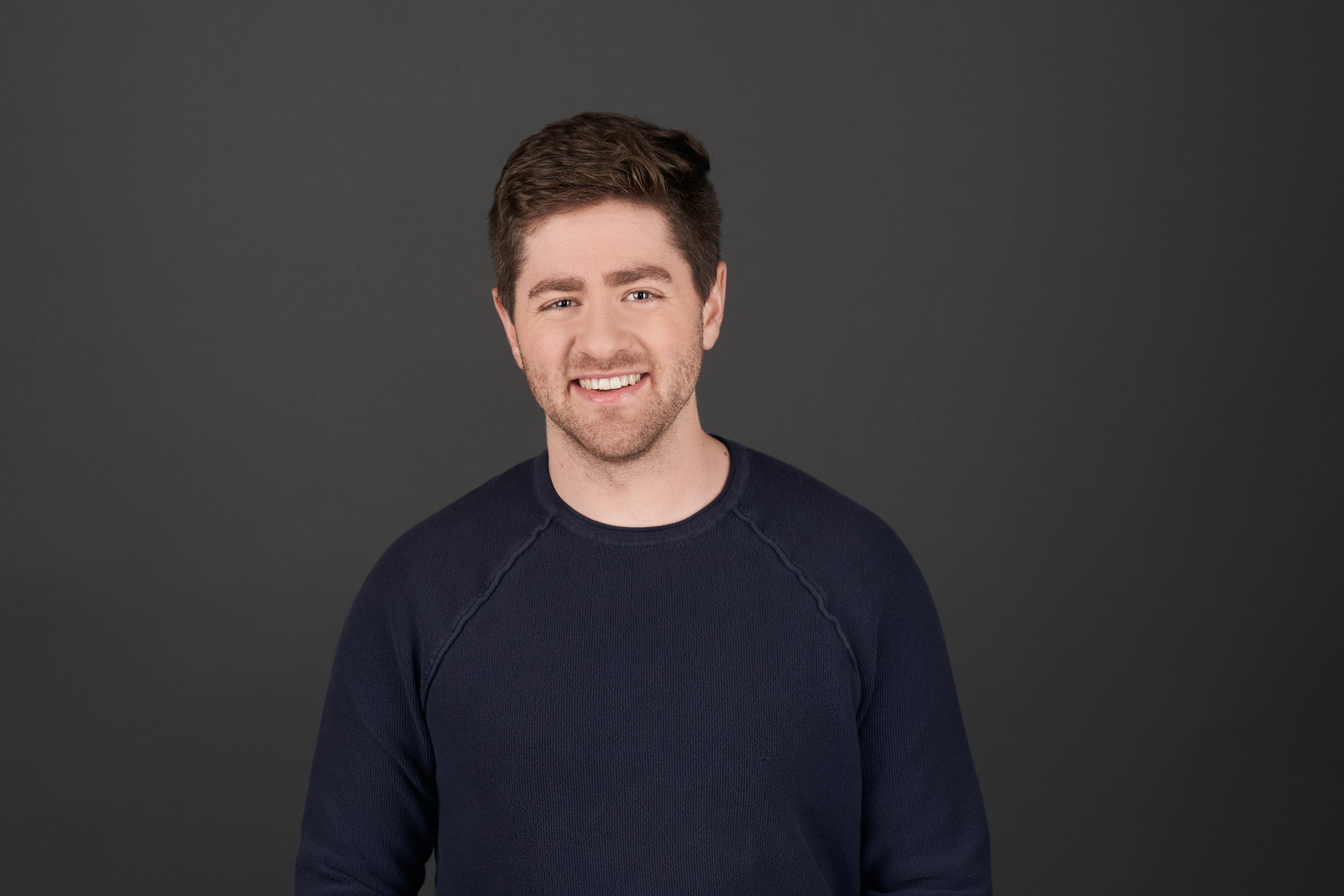 man in black shirt smiling for a portrait