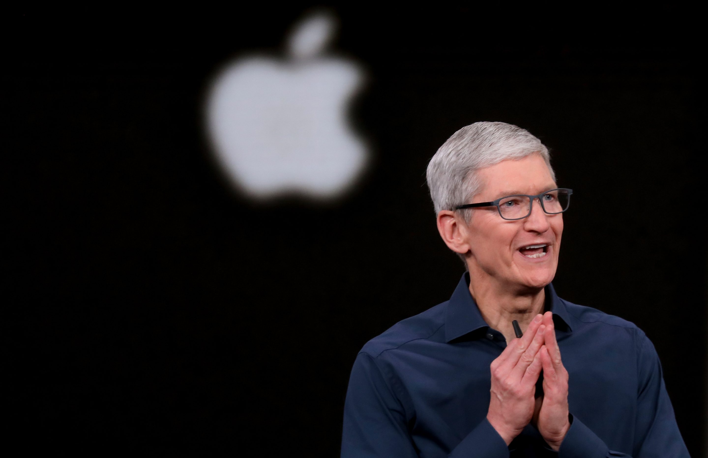 Tim Cook is seen in front of the Apple logo.