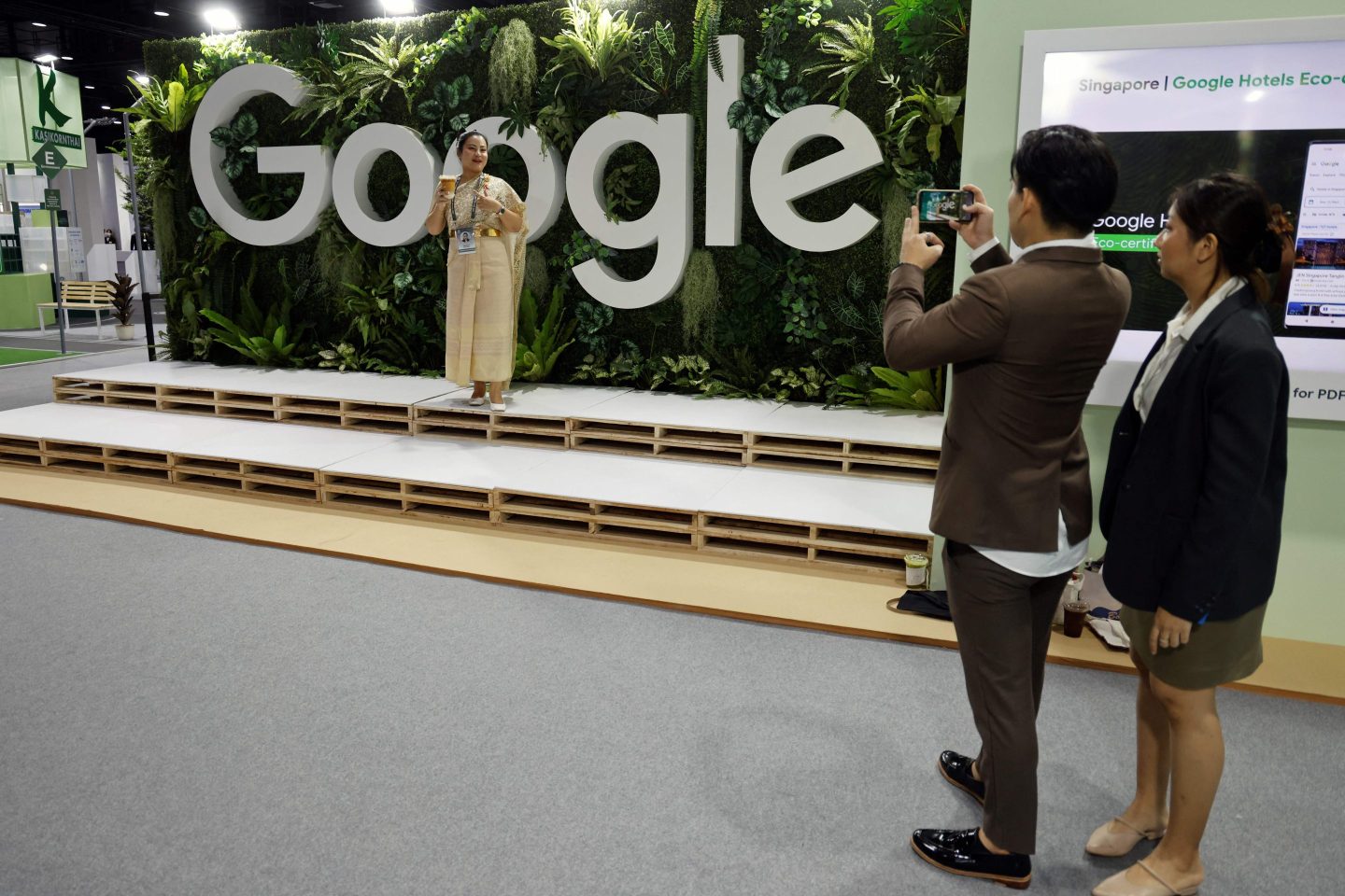 People take photos as another poses on a Google stand at the international media centre during the Asia-Pacific Economic Cooperation (APEC) summit in Bangkok on Nov. 18, 2022.