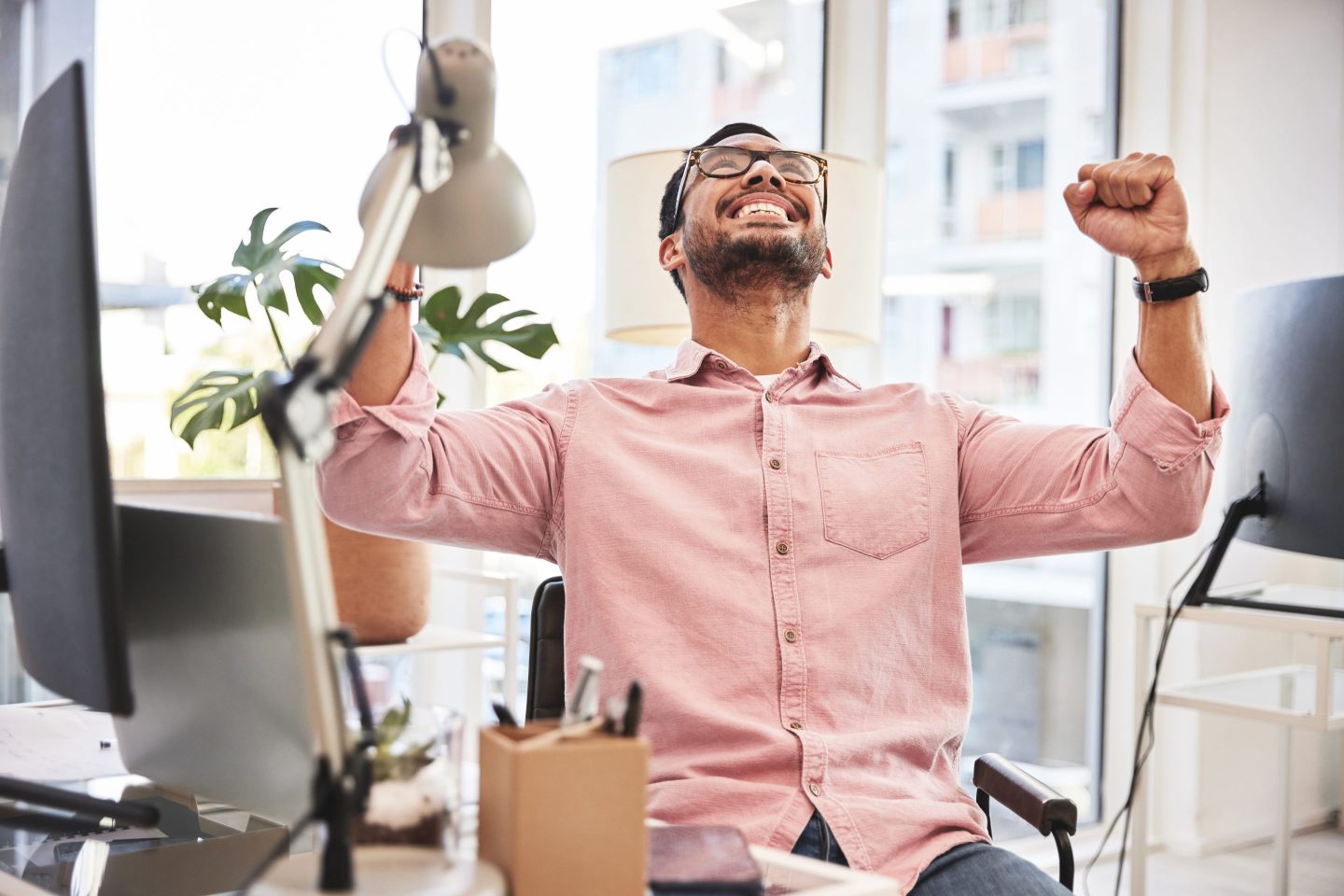Worker cheers at desk.