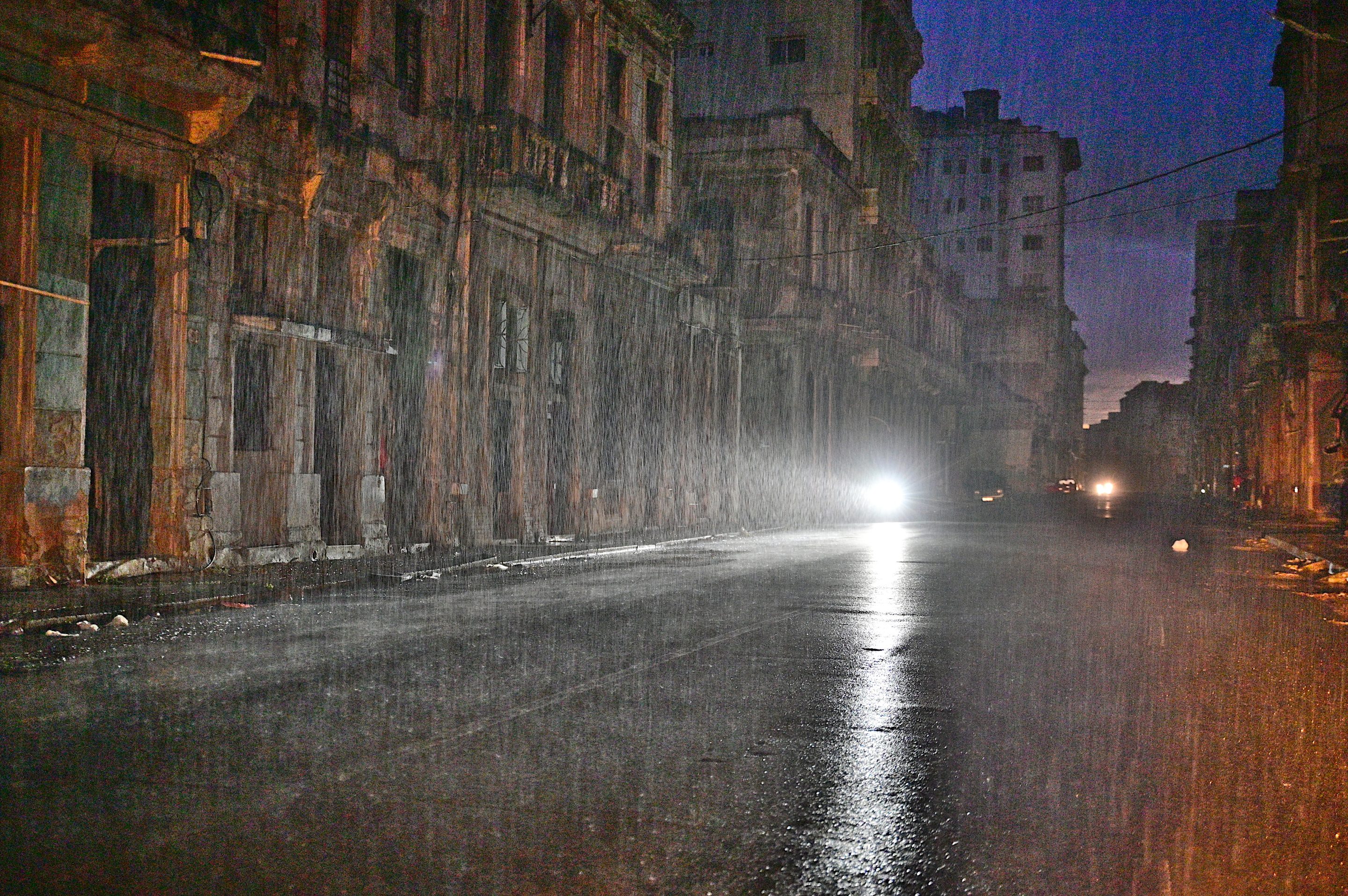 A motorcycle lights a street under pouring rain during a nationwide blackout caused by a grid failure in Havana, on Oct. 19, 2024.