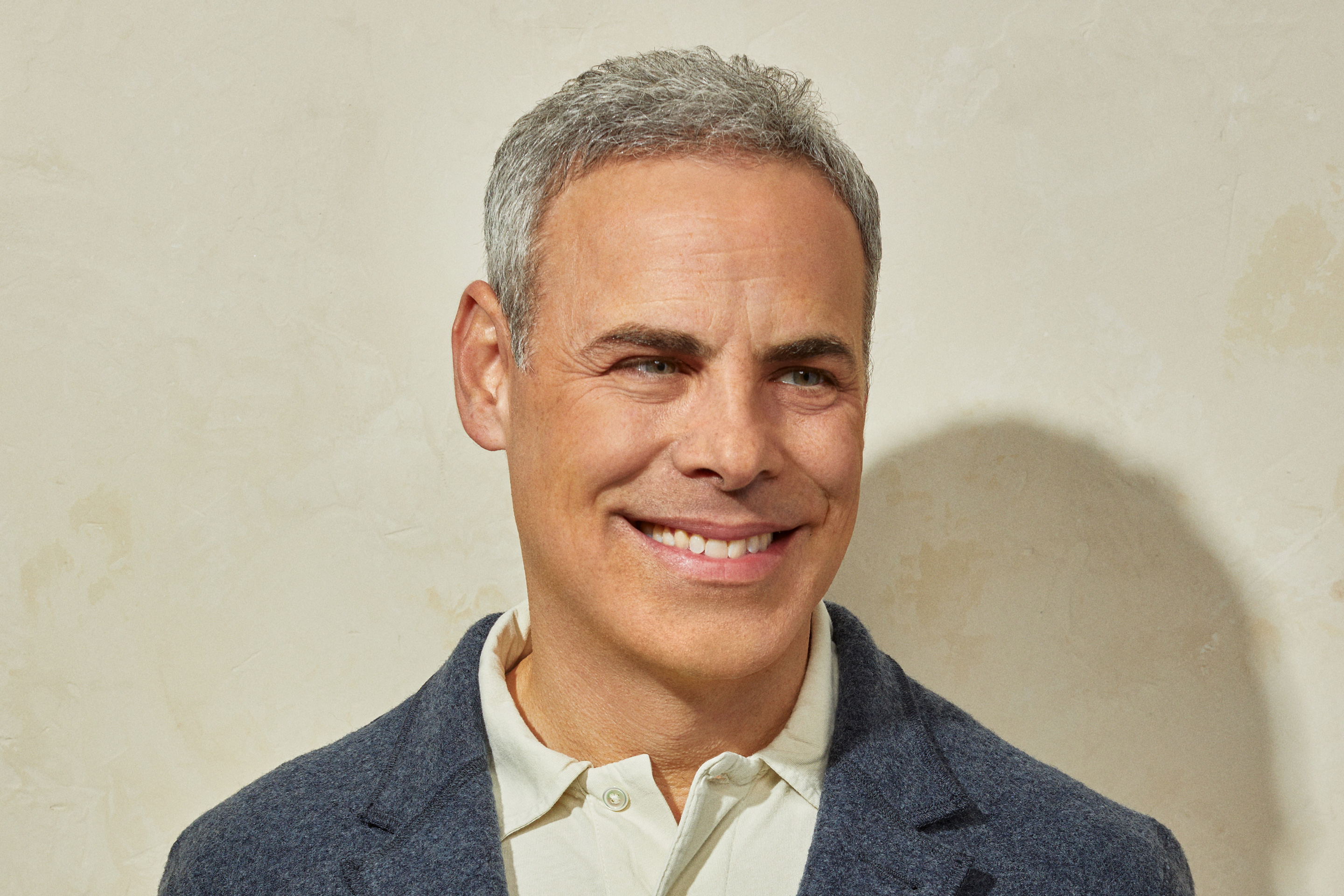 Cava CEO Brett Schulman smiles and looks to his left for a headshot.