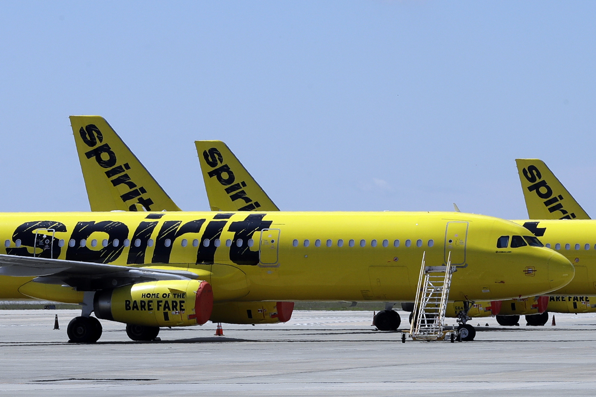 Two Spirit Airlines planes sit on a tarmac