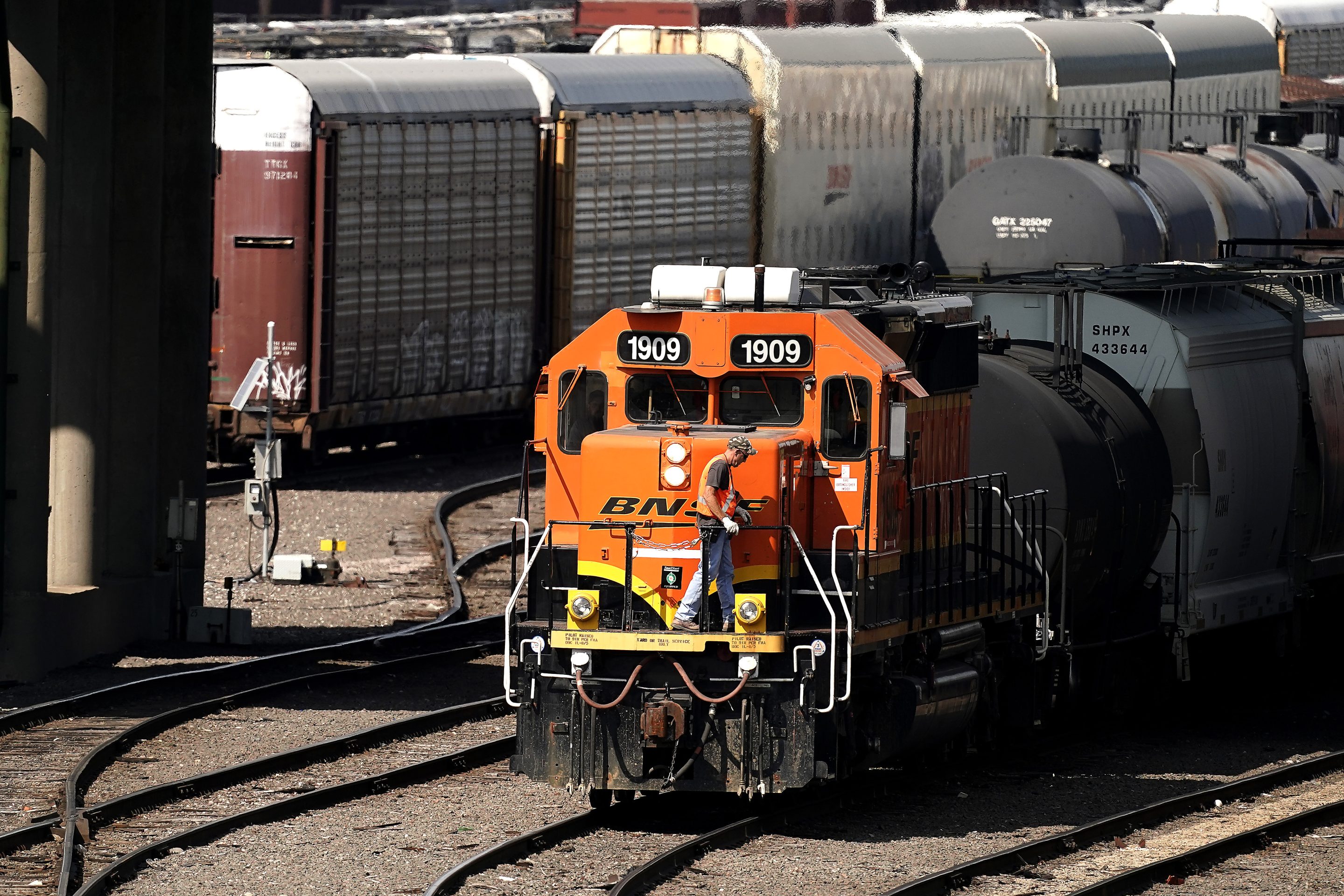 A worker boards a locomotive at a BNSF rail yard, Sept. 14, 2022, in Kansas City, Kan.