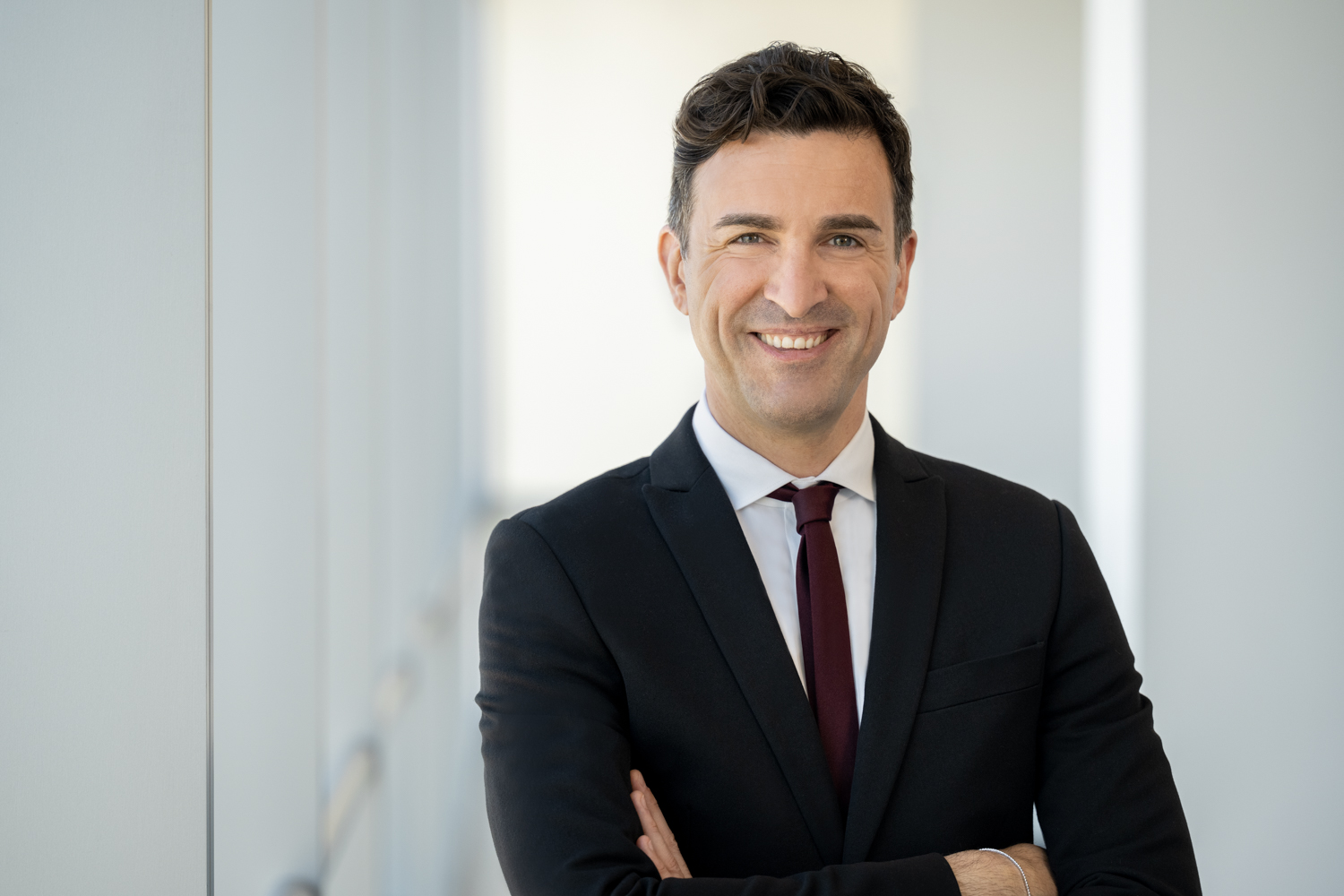 businessman wearing a suit with his arms crossed posed for a photo
