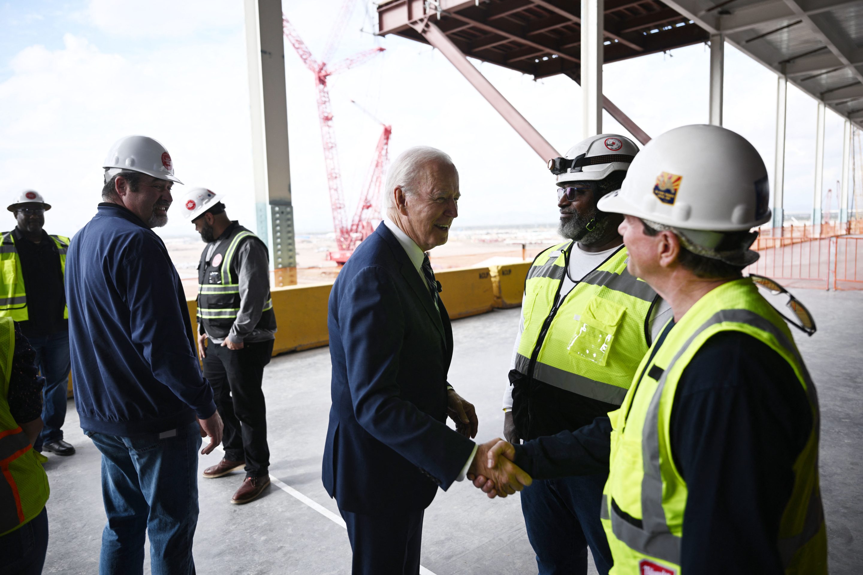 US President Joe Biden (C) greets workers as he tours the TSMC Semiconductor Manufacturing Facility in Phoenix, Arizona, on December 6, 2022.