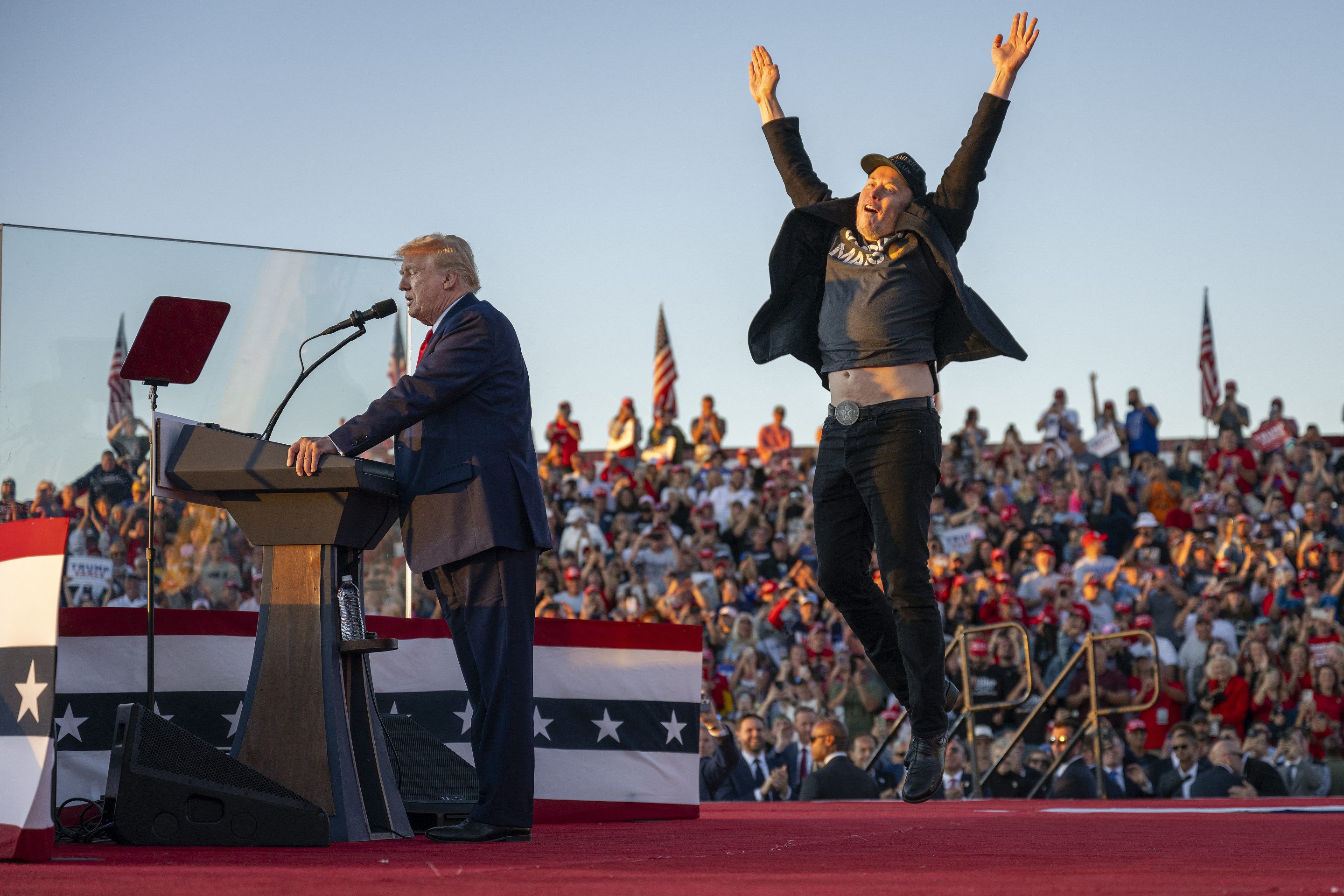 Elon Musk jumping in the air on stage at an October 2024 rally for Donald Trump.