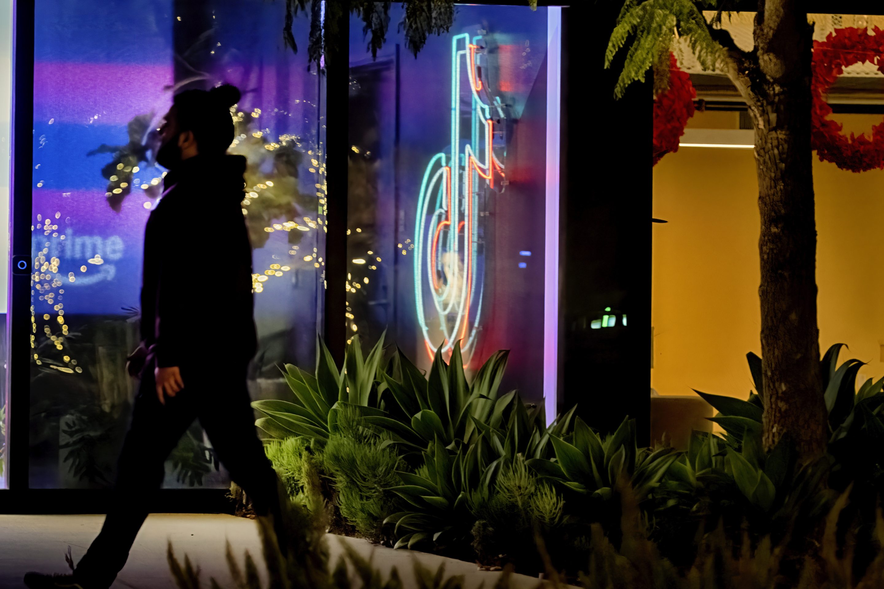 A neon TikTok logo hangs in the lobby of the TikTok office building