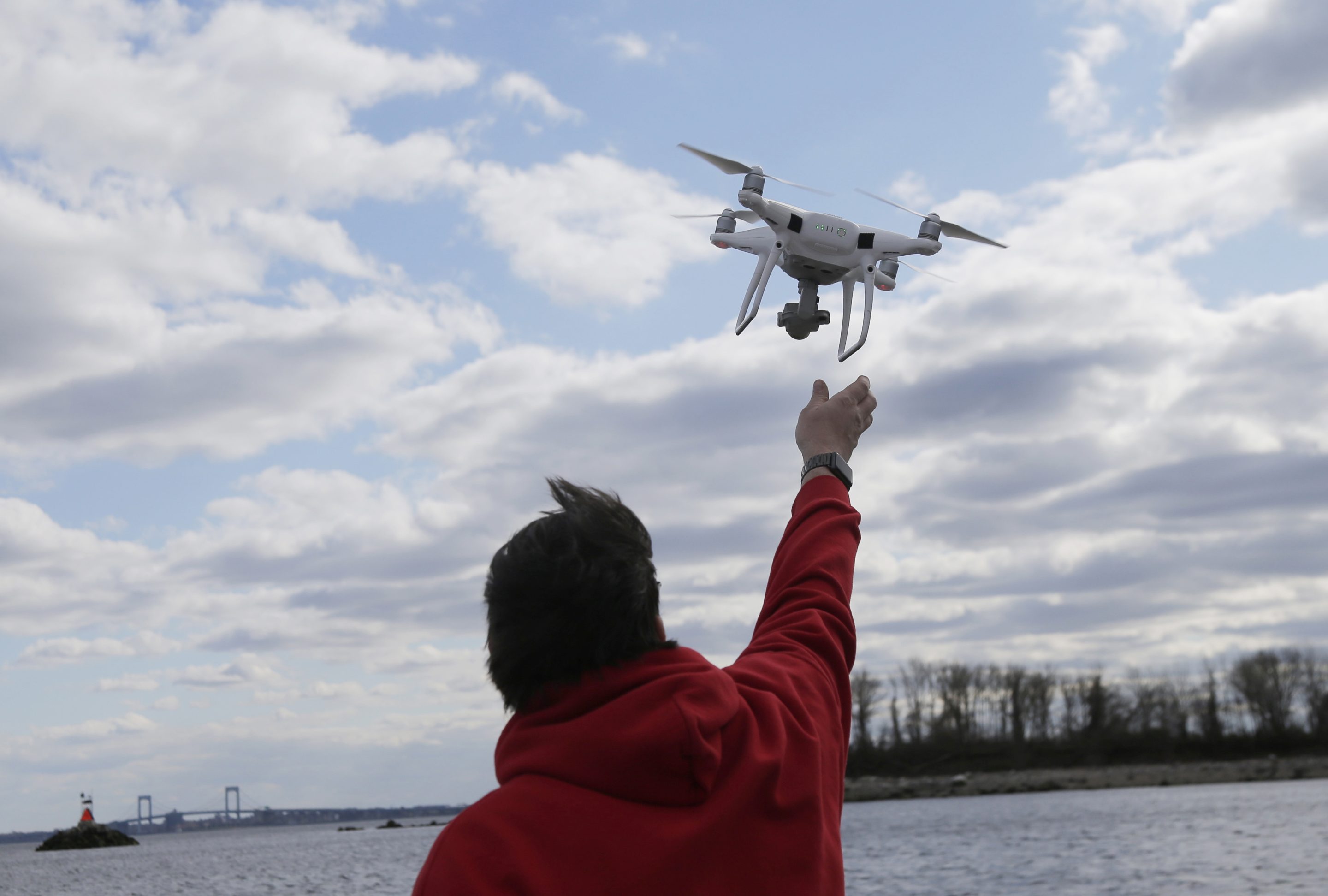 A drone operator helps to retrieve a drone after photographing over Hart Island in New York, on April 29, 2018.