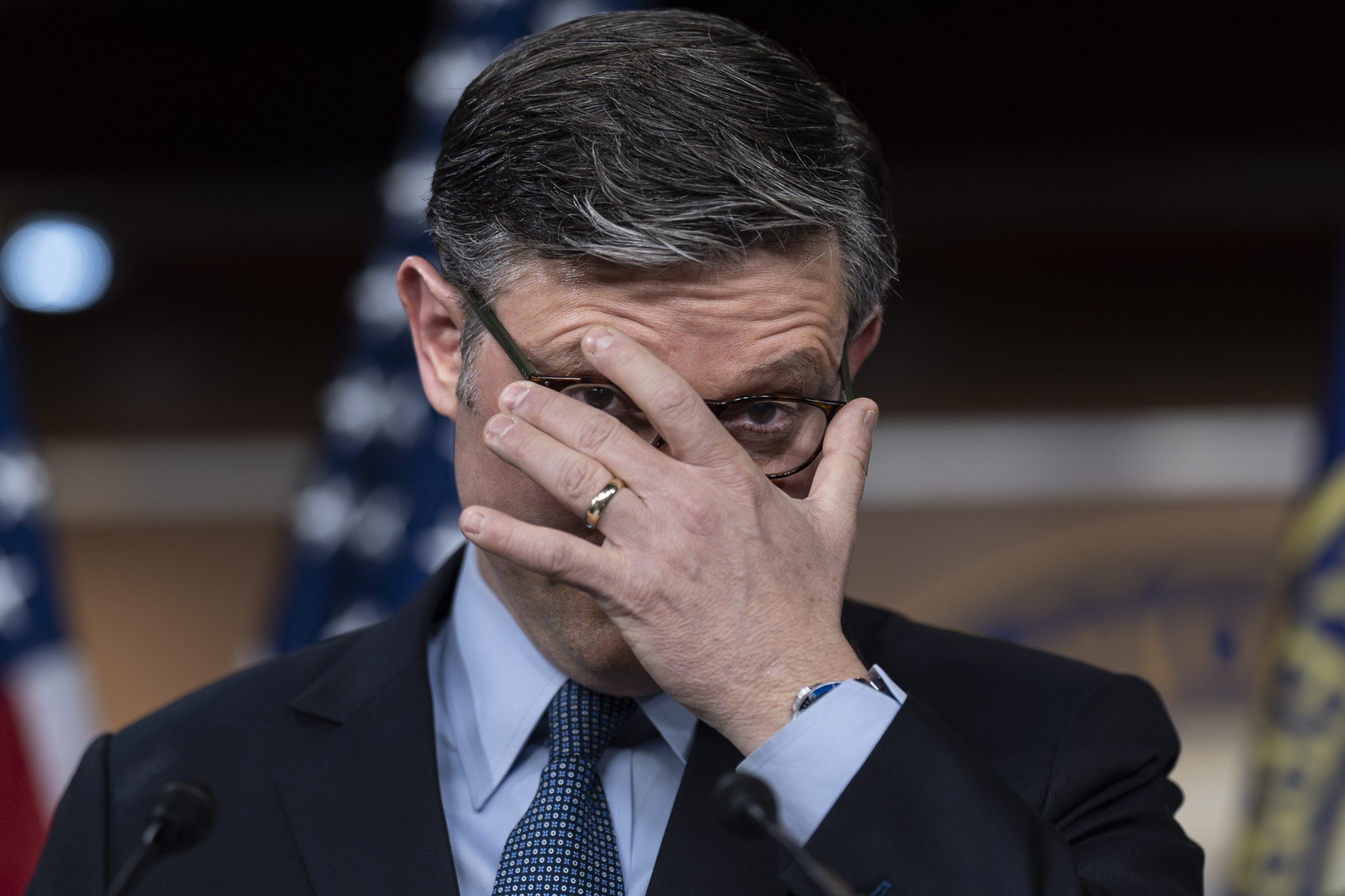 House Speaker Mike Johnson adjusts his glasses